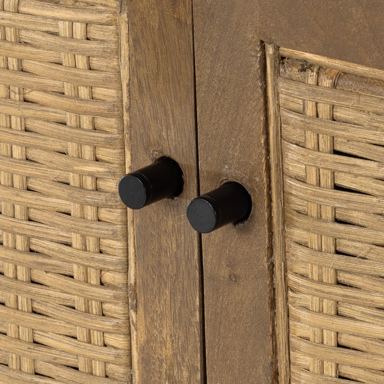 Close up of a wooden sideboard with rattan doors on a white background.