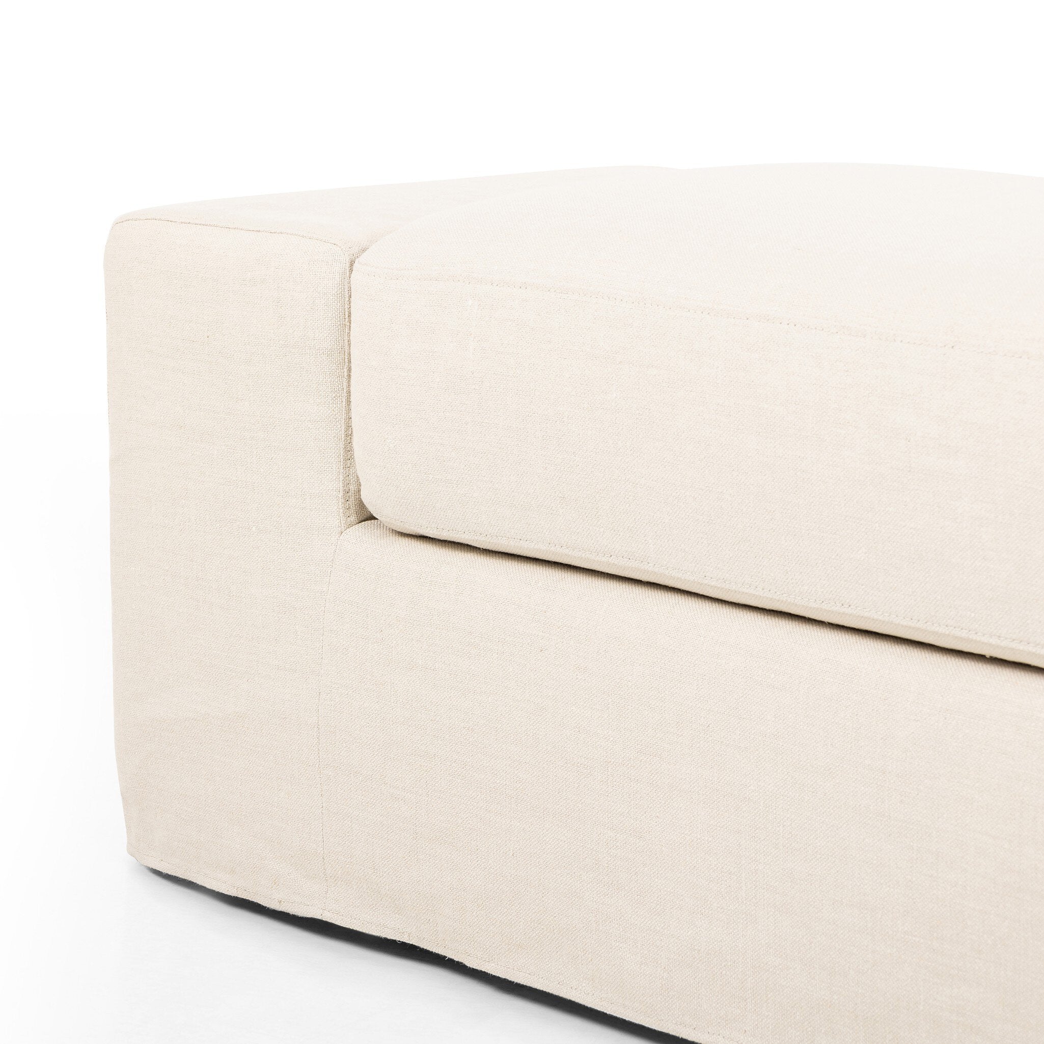 Ivory wide arm slipcover accent bench on a white background.