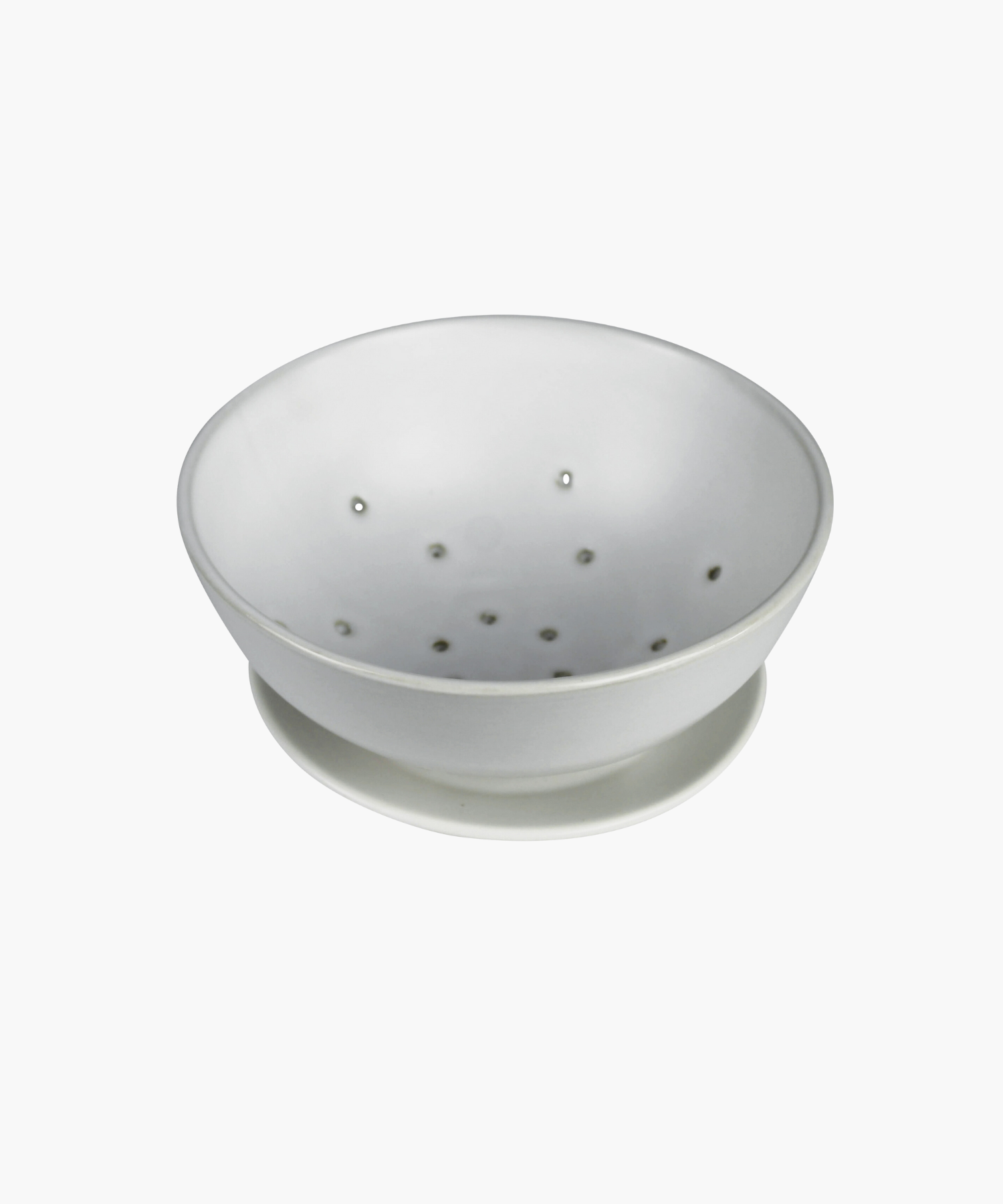White ceramic colander with matching base plate. The minimalist design features a smooth matte finish, subtle curves, and small drainage holes.