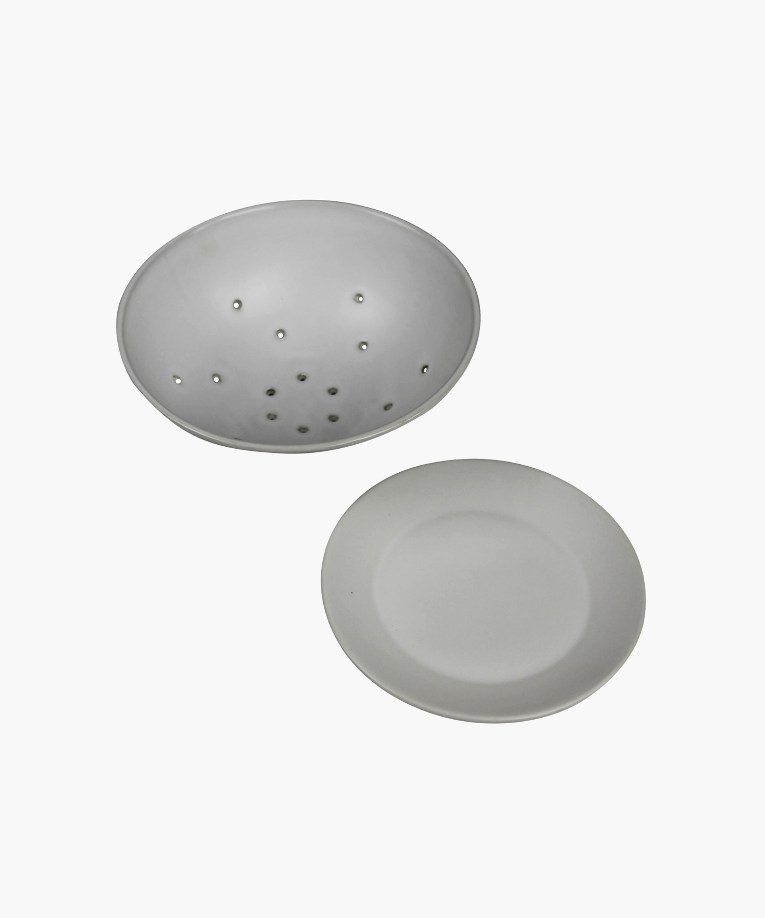 White ceramic colander with matching base plate. The minimalist design features a smooth matte finish, subtle curves, and small drainage holes.