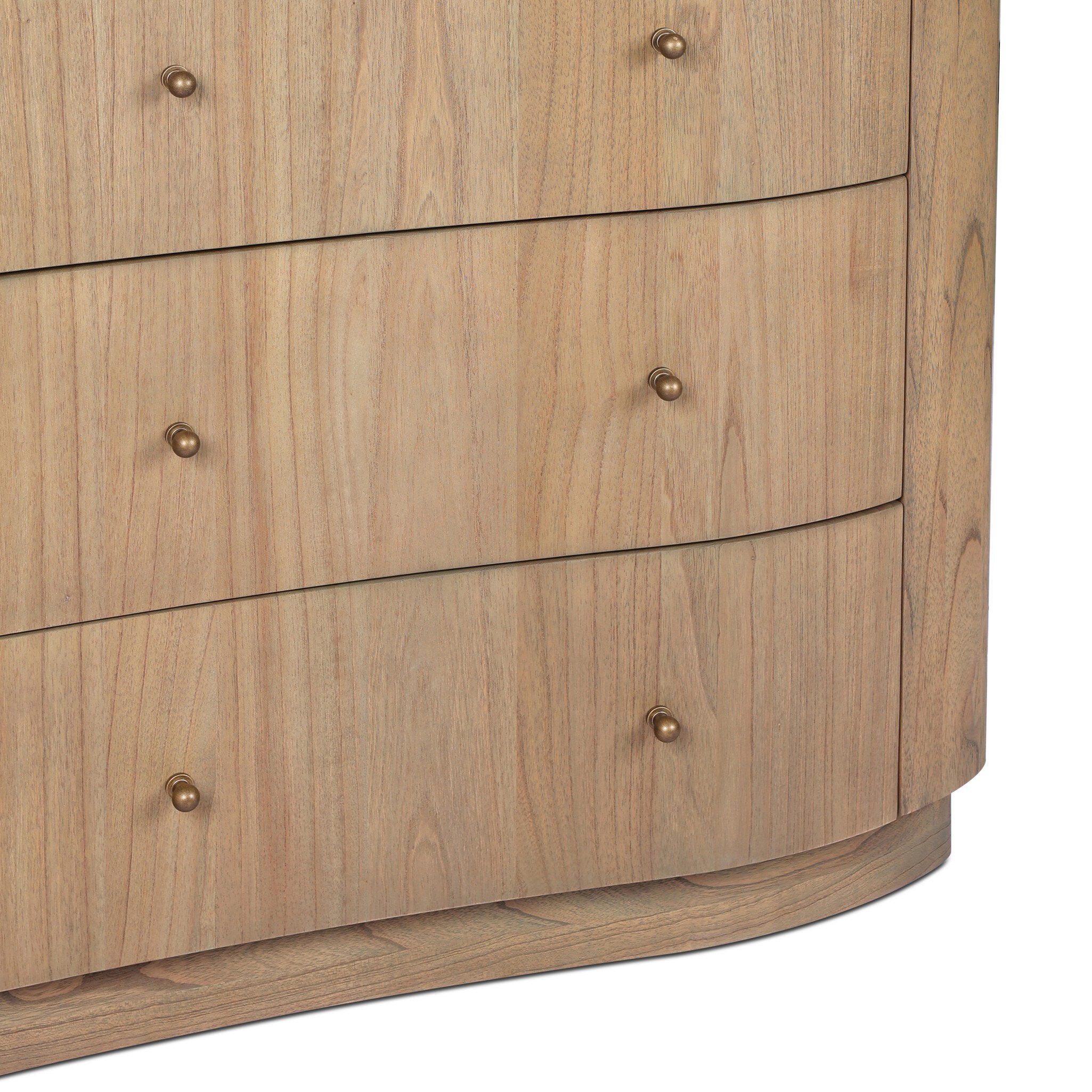 Close up of a wooden dresser highlighting three of the six drawers and brass knobs on a white background.
