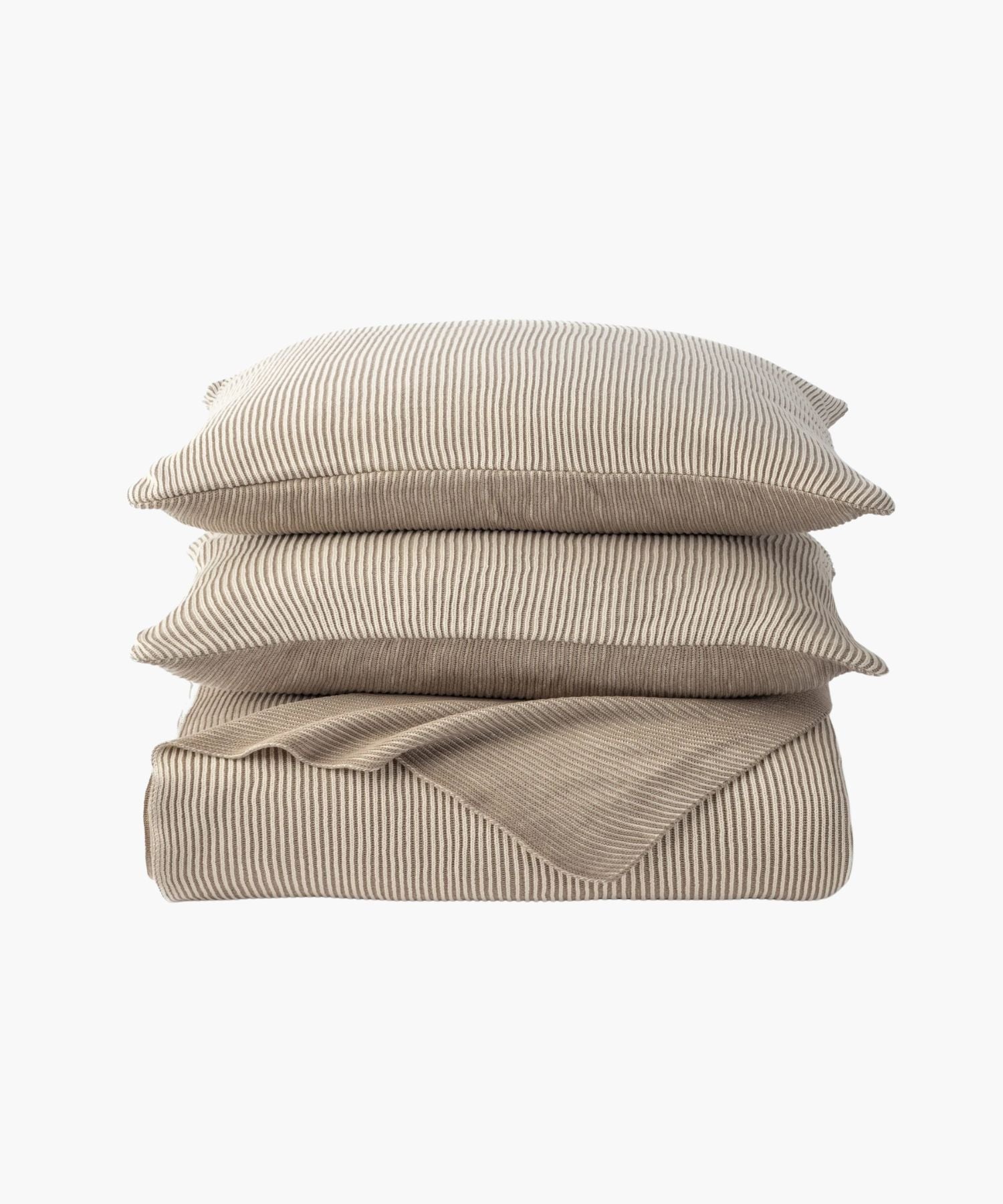 Stacked image of two shams atop the coverlet, emphasizing the knit ribbing and coordinated design in a cream tone.