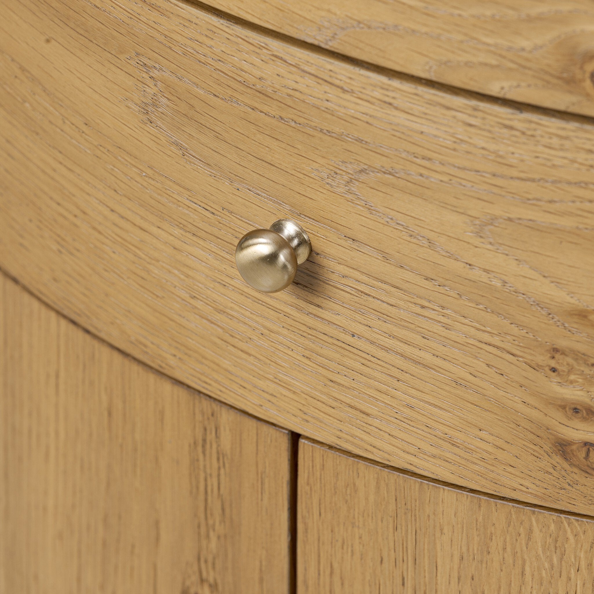 Close up of a crescent style night stand with doors and cream marble top. 