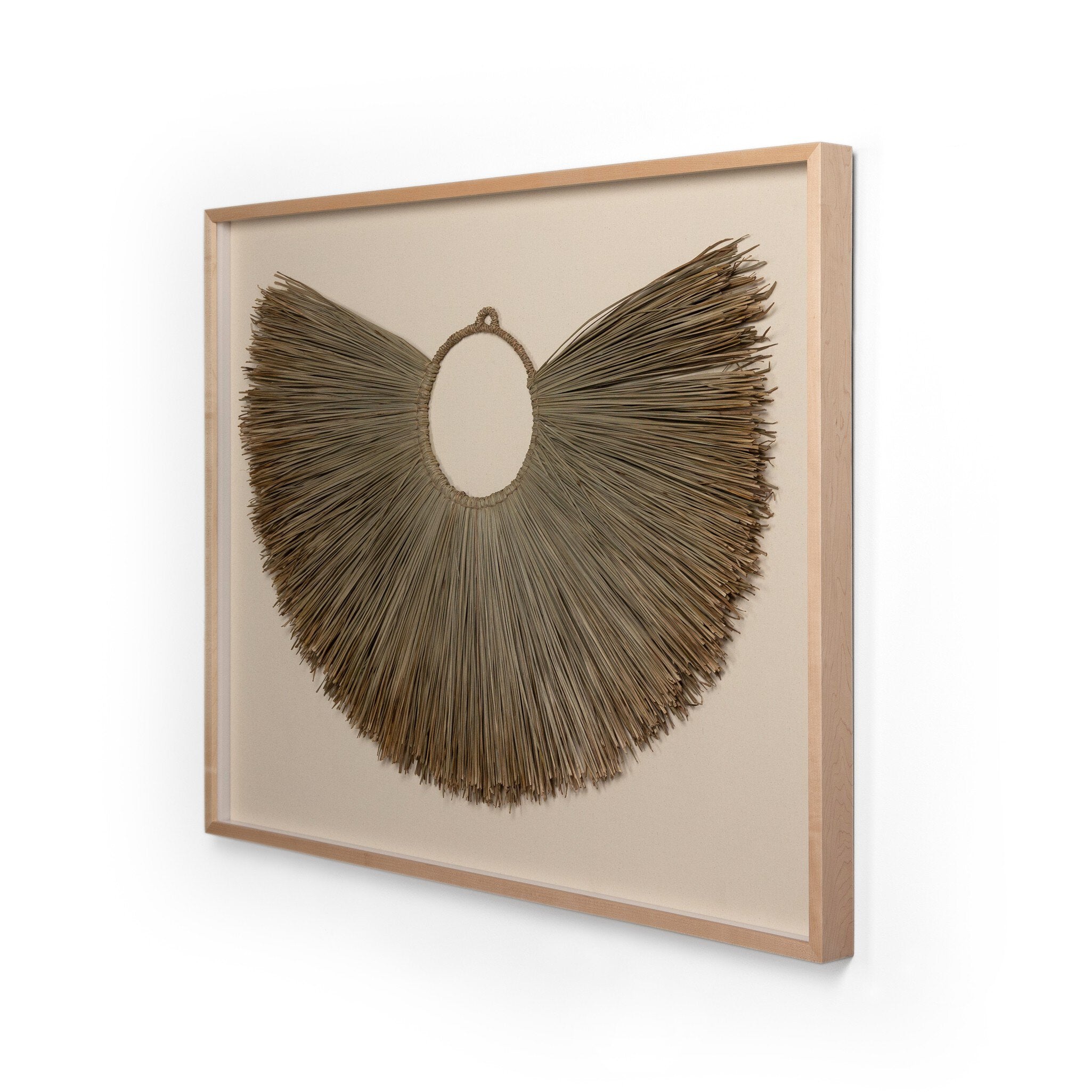 Framed palm leaf decorative wall art with a circular, fan-like design on a beige background.