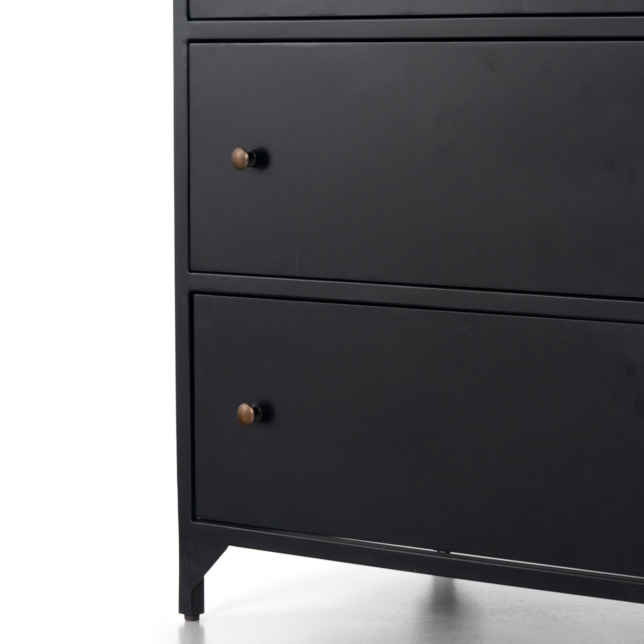 A close up of a black dresser with three drawers and metallic knobs on a white background.