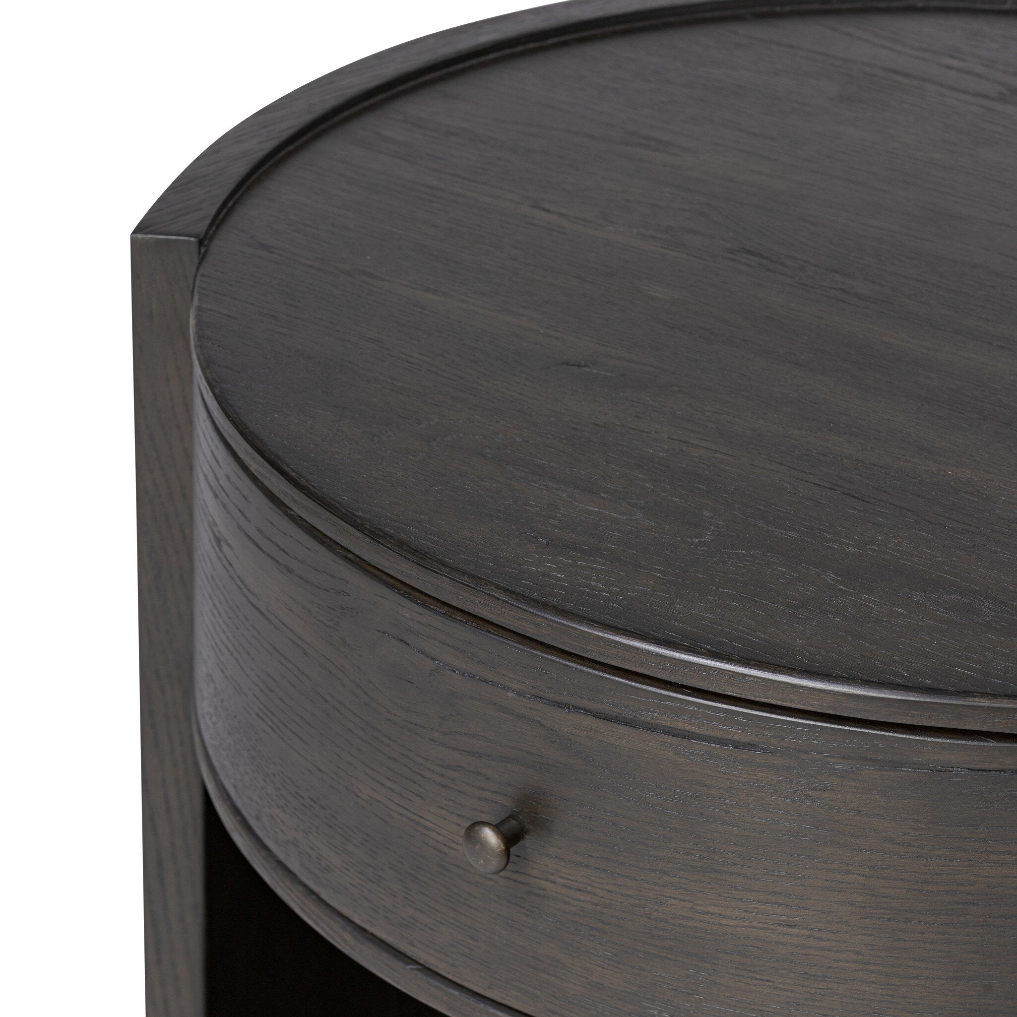 Close up of a round dark wooden nightstand with a drawer and a cubby on a white background.