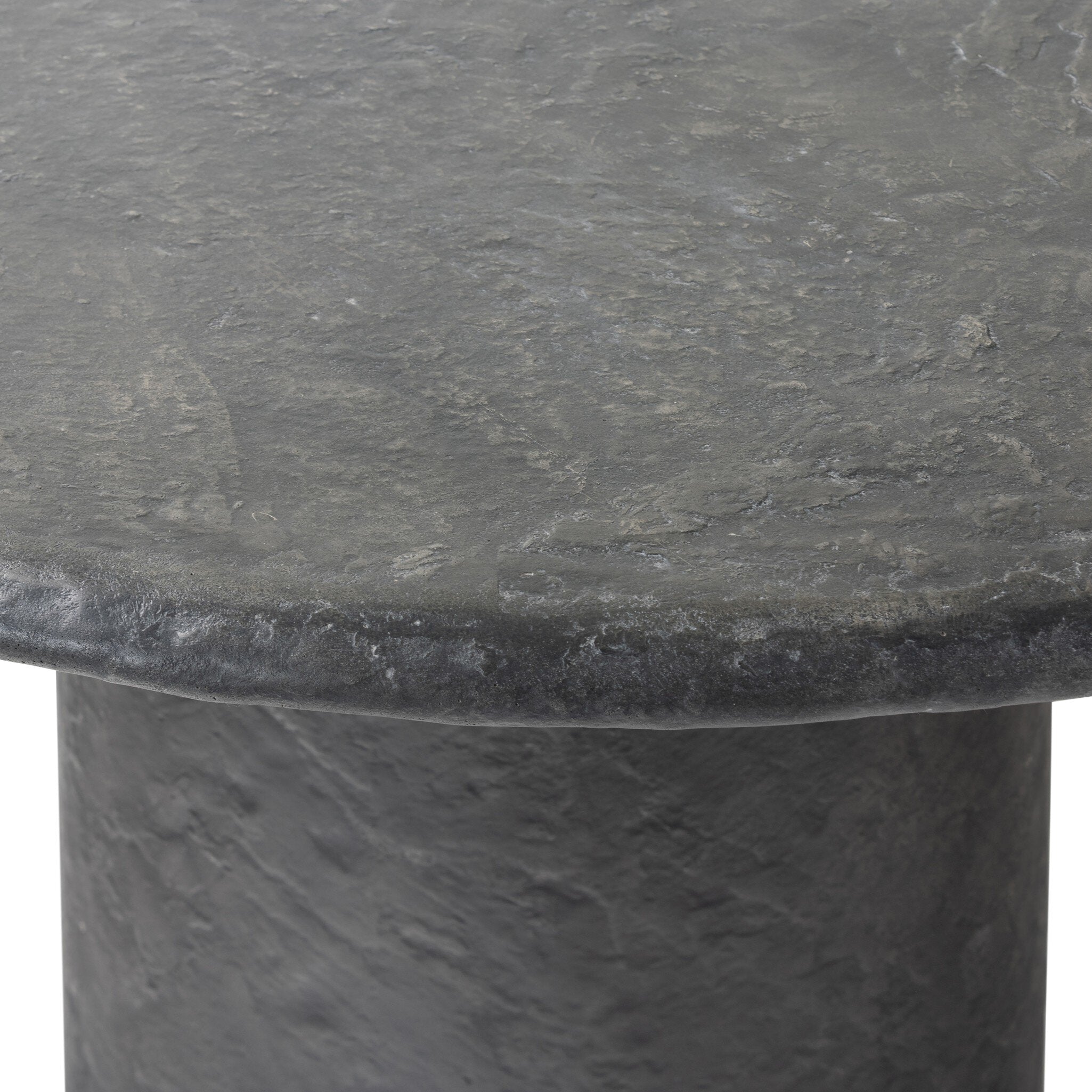 Close up of a round black concrete dining table on a white background.