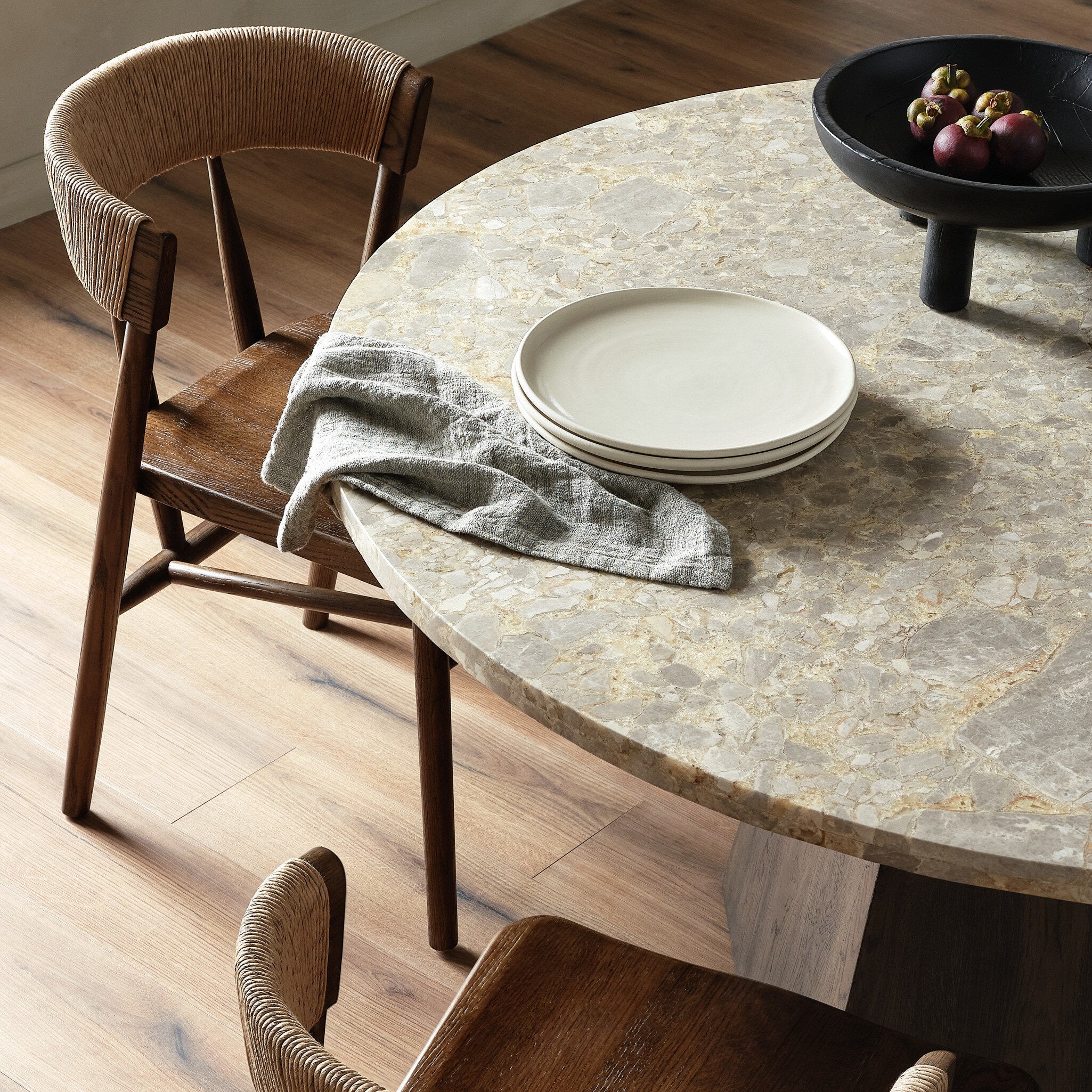 Round stone table with wooden chairs in a dining setting