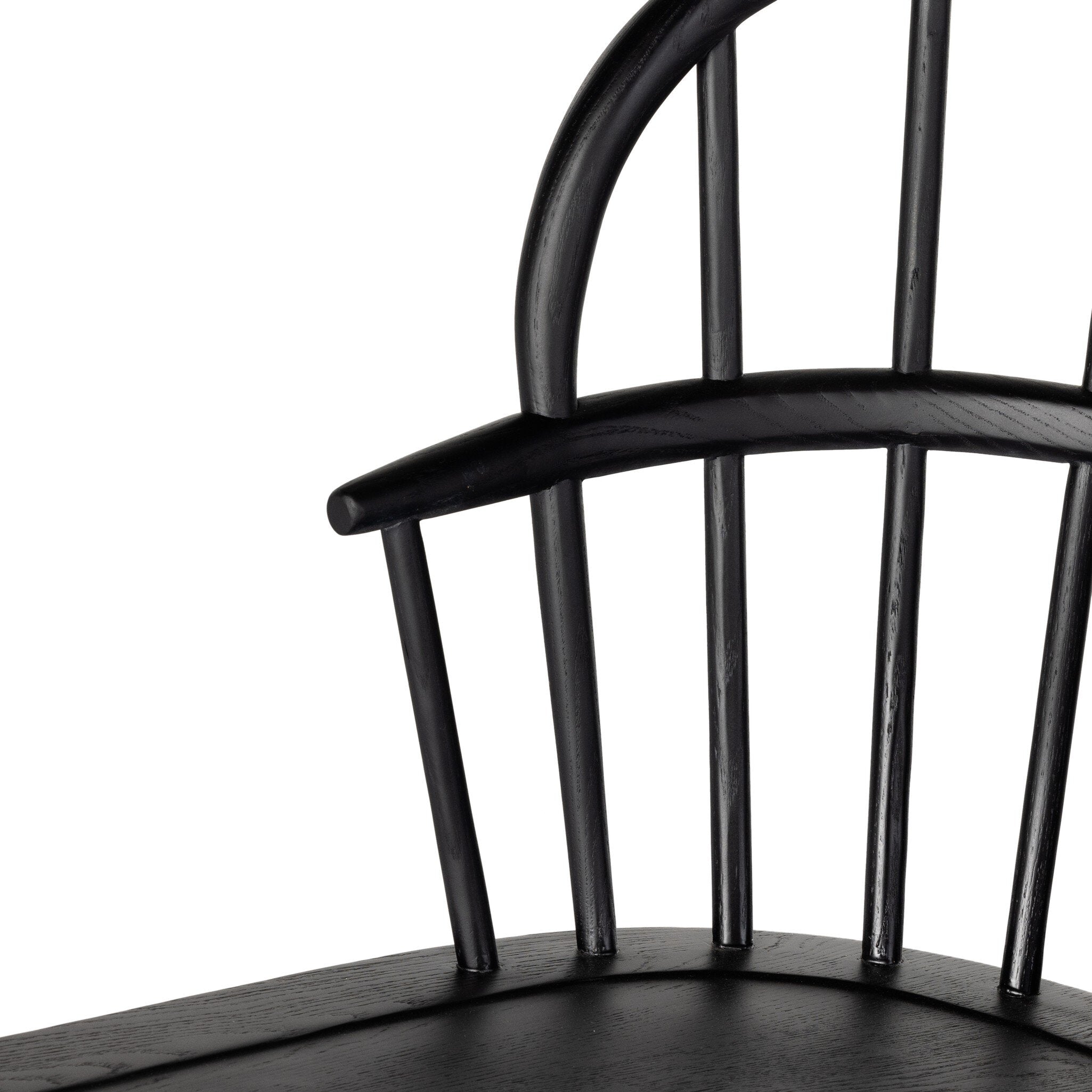 Close up of a black dining chair with a minimalist design on a white background.