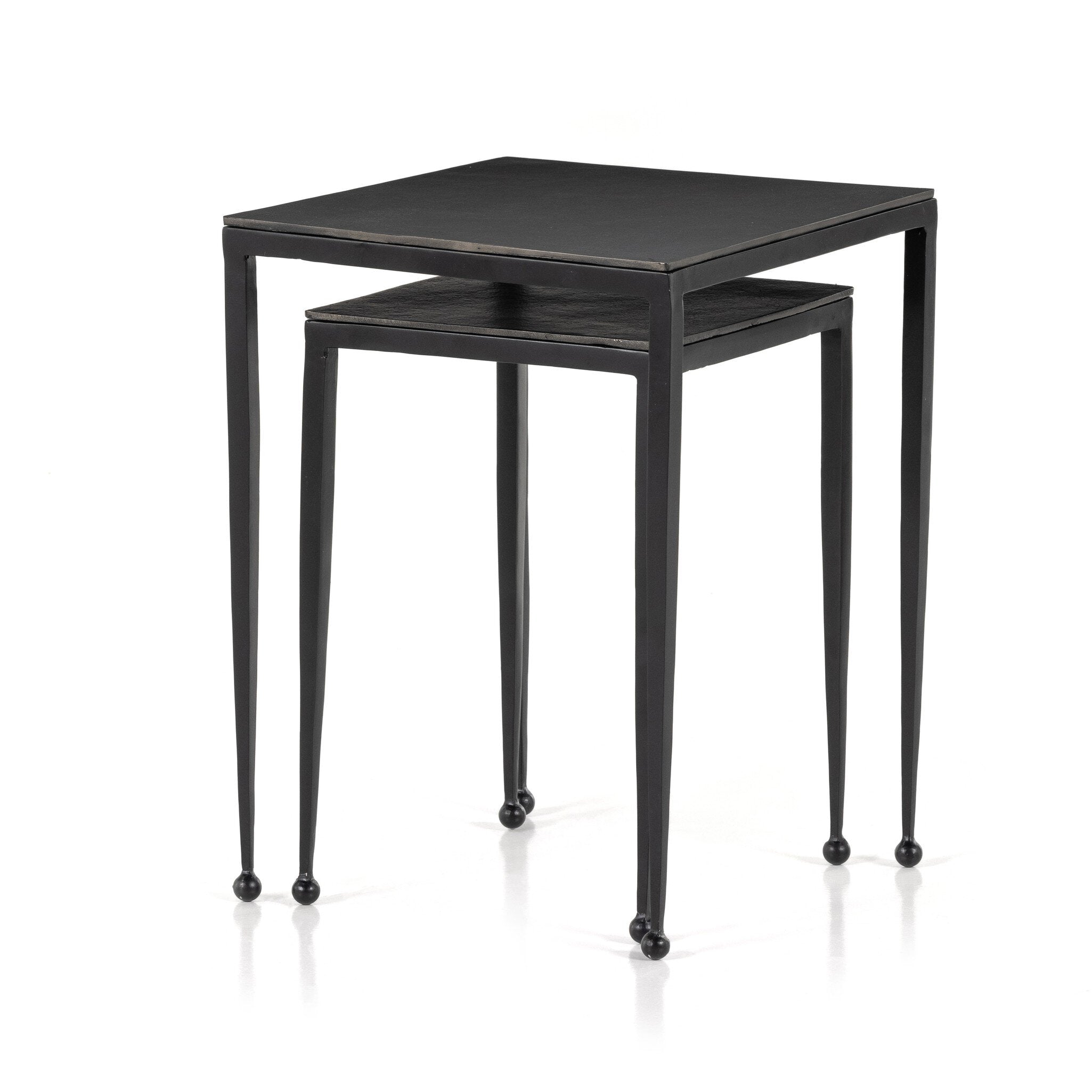 Two black nesting tables with tapered legs and squared off aluminum tops on a white background.