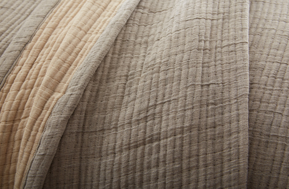 Close-up of textured greyish brown fabric with a focus on color and texture.