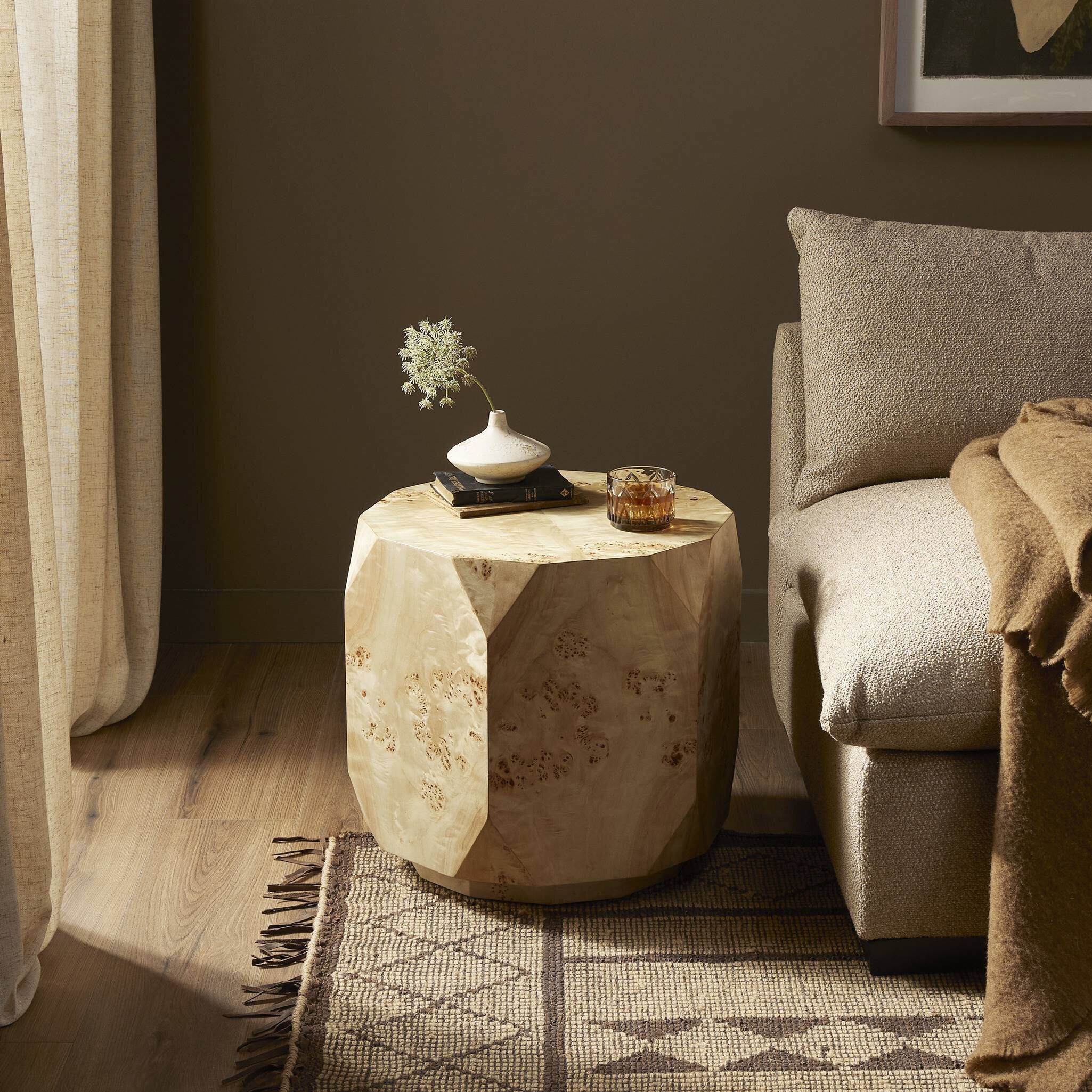 Wooden side table with decorative items next to a sofa in a living room.