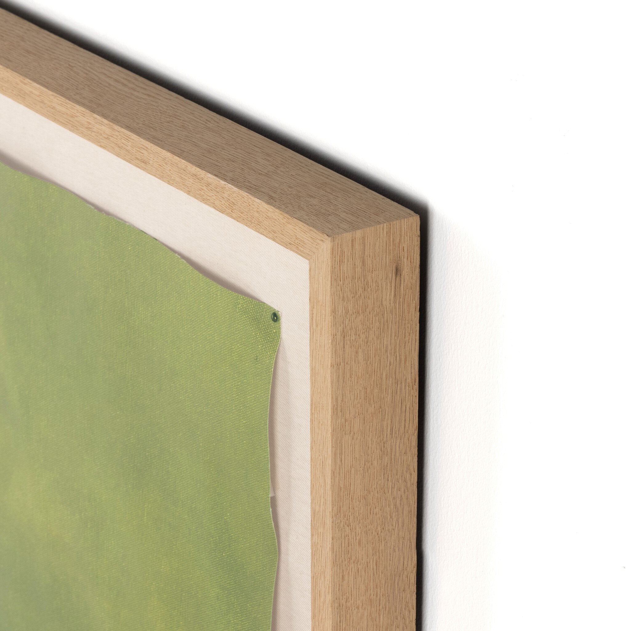 Close-up of a wooden picture frame with a green canvas inside.