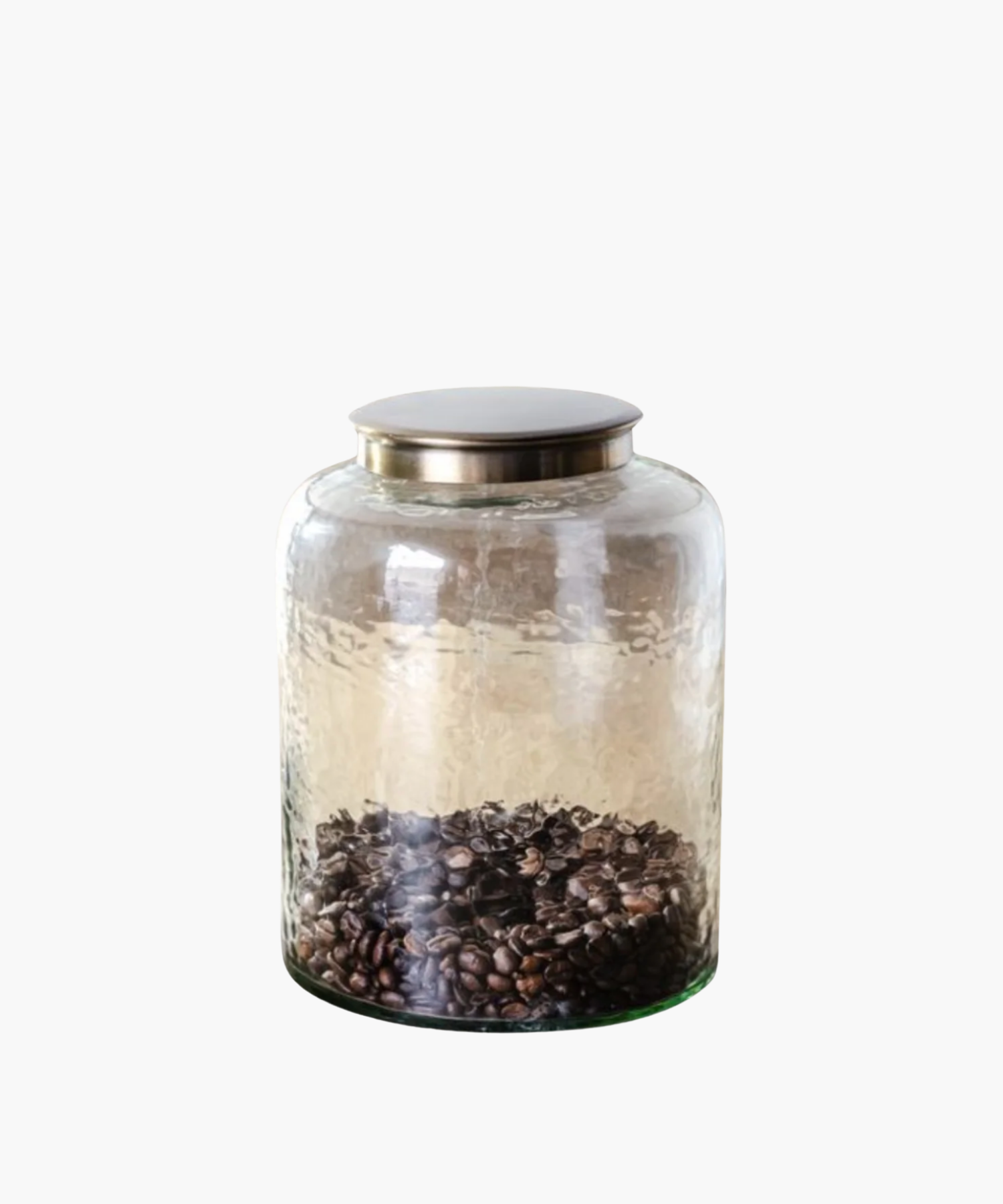 A transparent glass jar with a metallic lid, containing a layer of dark coffee beans at the bottom. The jar exudes a minimalist and rustic vibe.