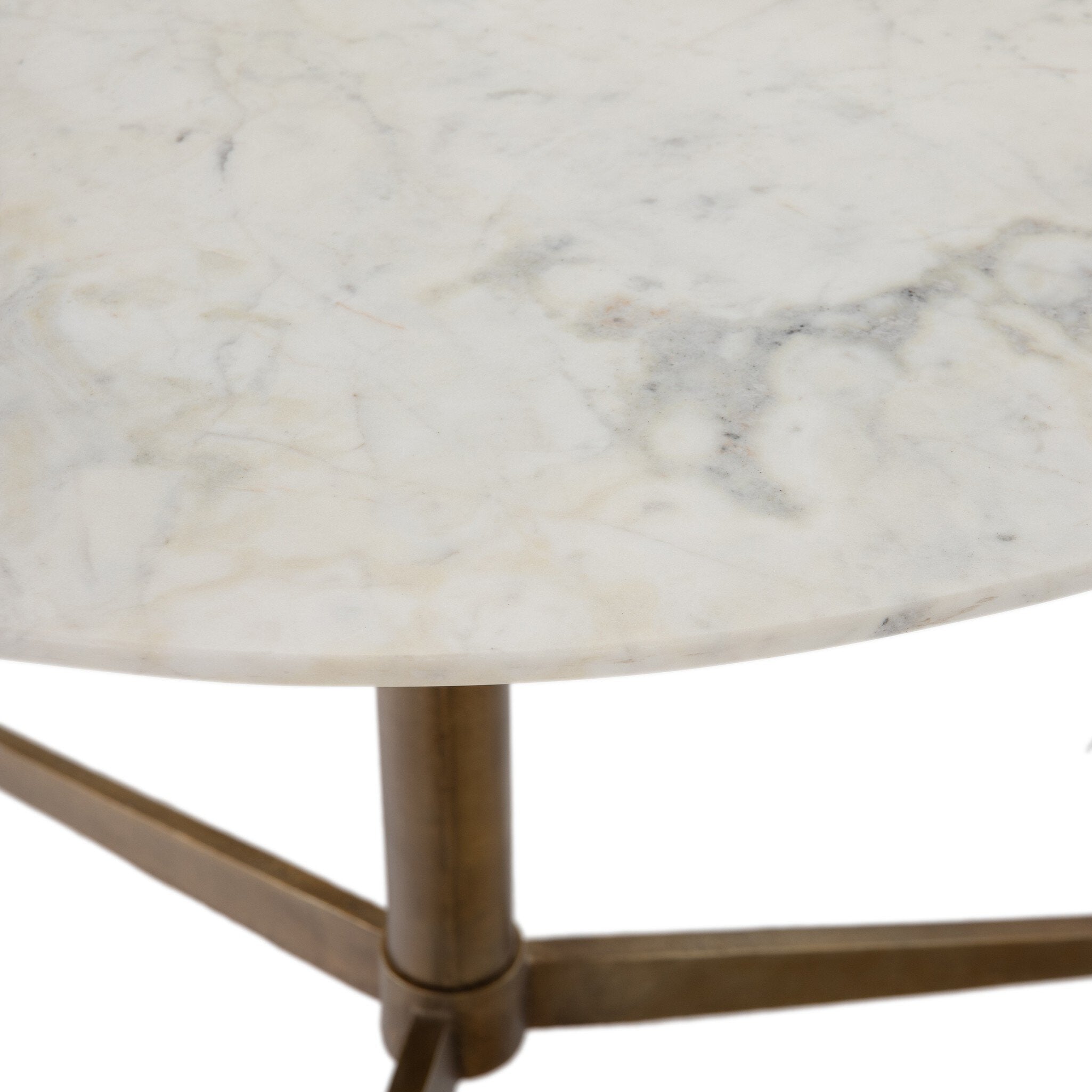 Close up of a round bistro table with marble top and bronze base on a white background.