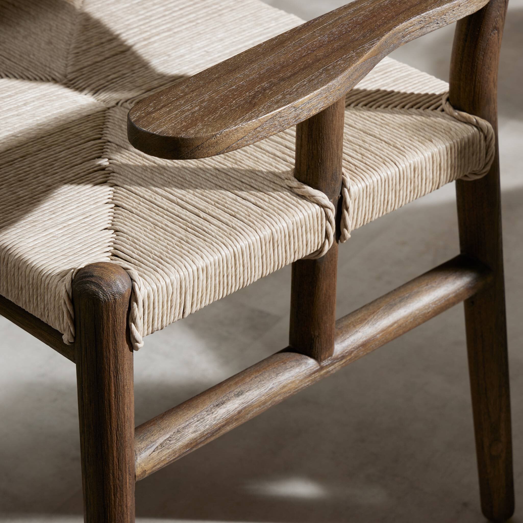 Close up of where woven pattern meet the arm of the chair from the outdoor dining armchair. 