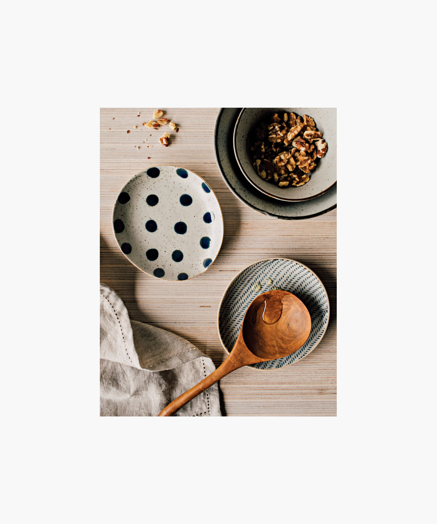 Round ceramic spoon rest with a diagonal blue herringbone pattern on a white background style with other kitchen serveware. The design is symmetrical, creating an elegant, minimalist look.