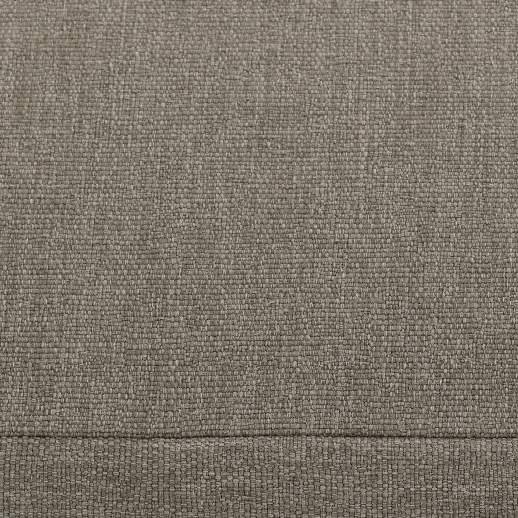 Close up of a slipcover gray outdoor ottoman showing its color and fabric texture. 