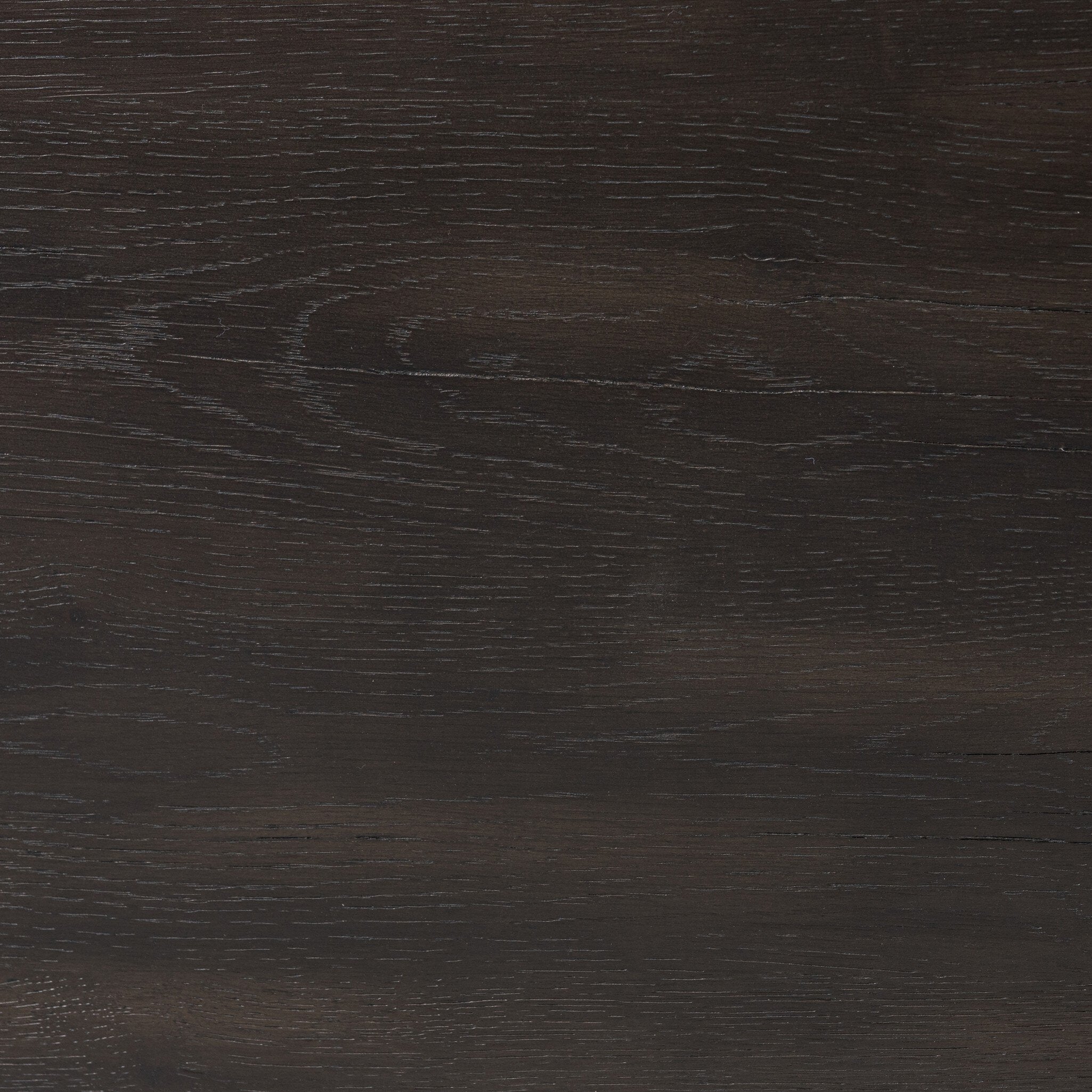 Close up of the top of the nightstand showing its dark color and wood grain. 