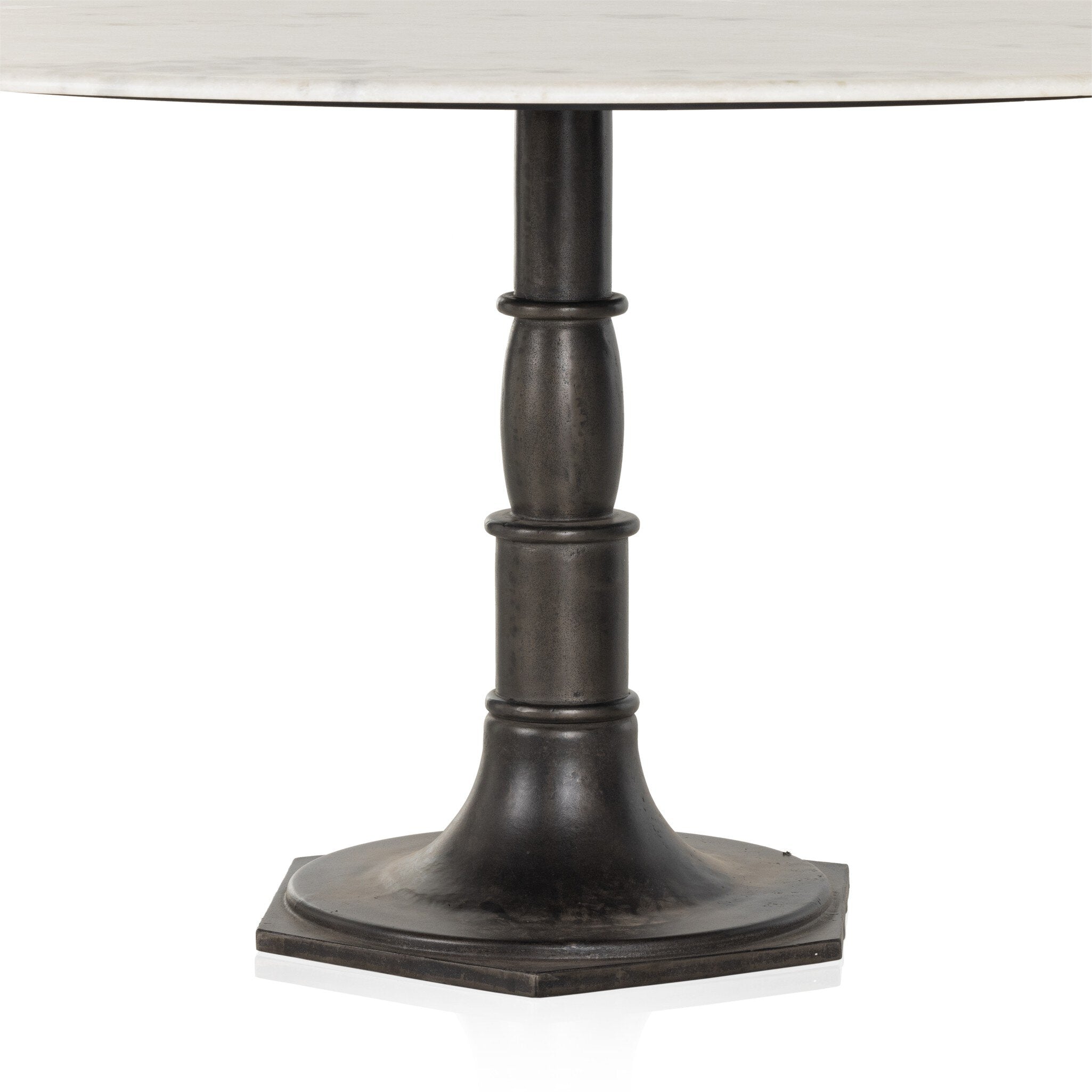 Close up of a round marble dining table with a black metal pedestal base on a white background.