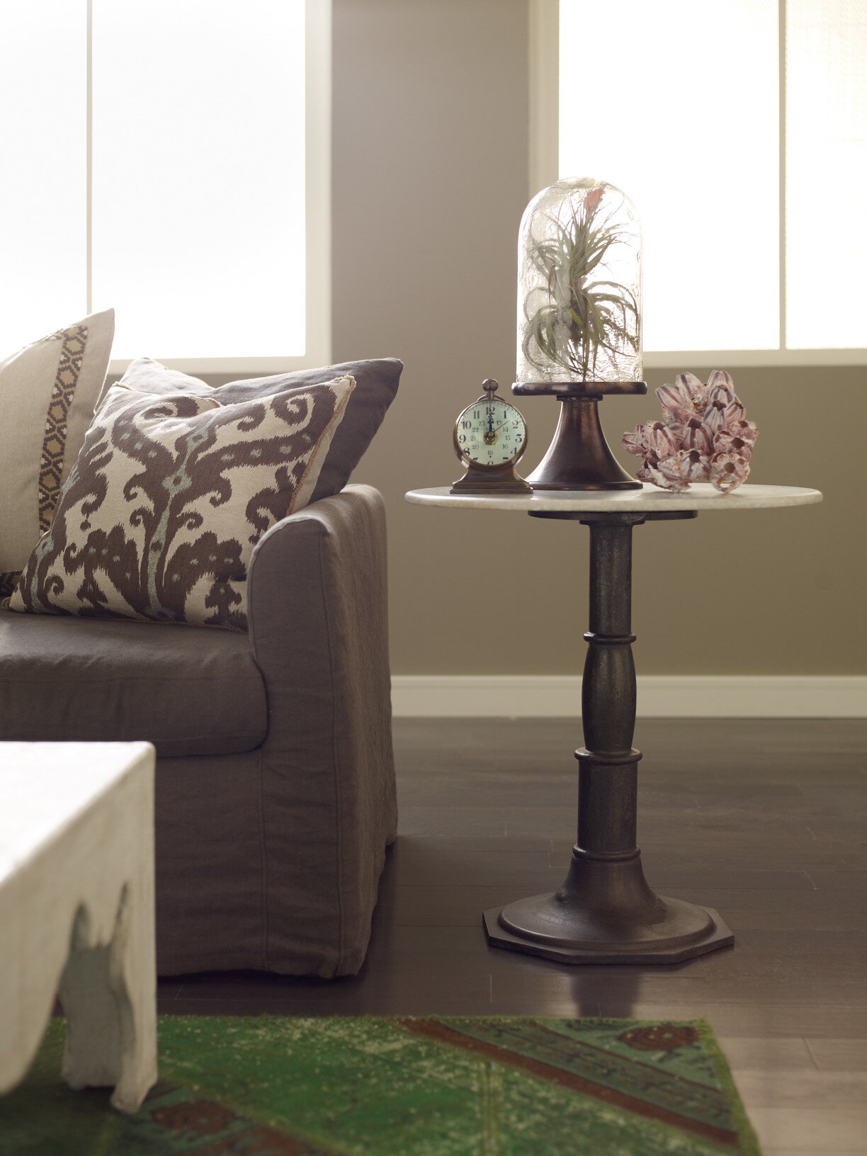 Living room with a sofa, decorative pillows, and a small table with a decorative item.