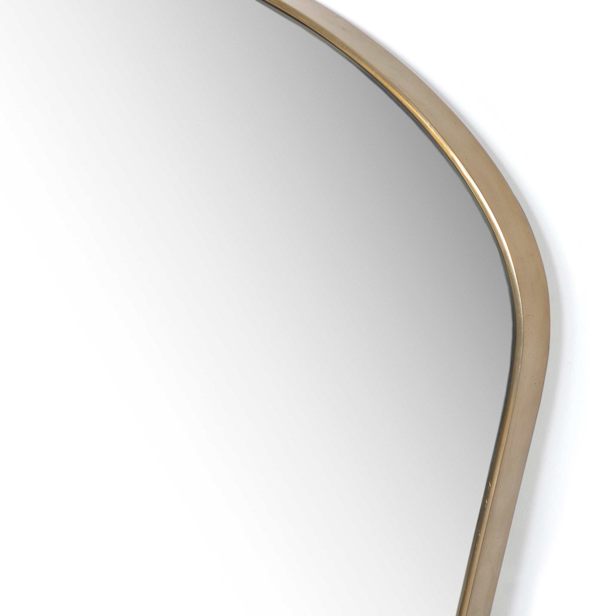 Close up of a decorative wall mirror with a gold frame on a white background.