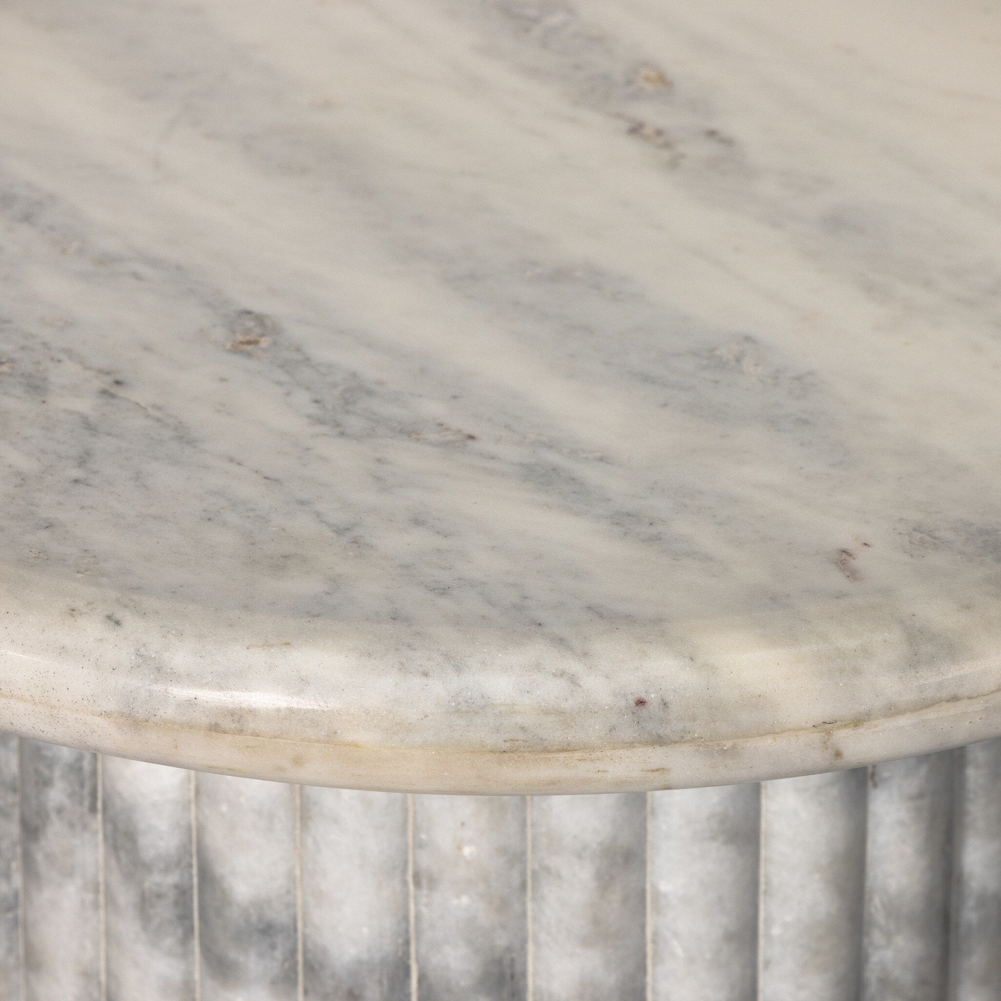 Close-up of a marble table with a ribbed base.