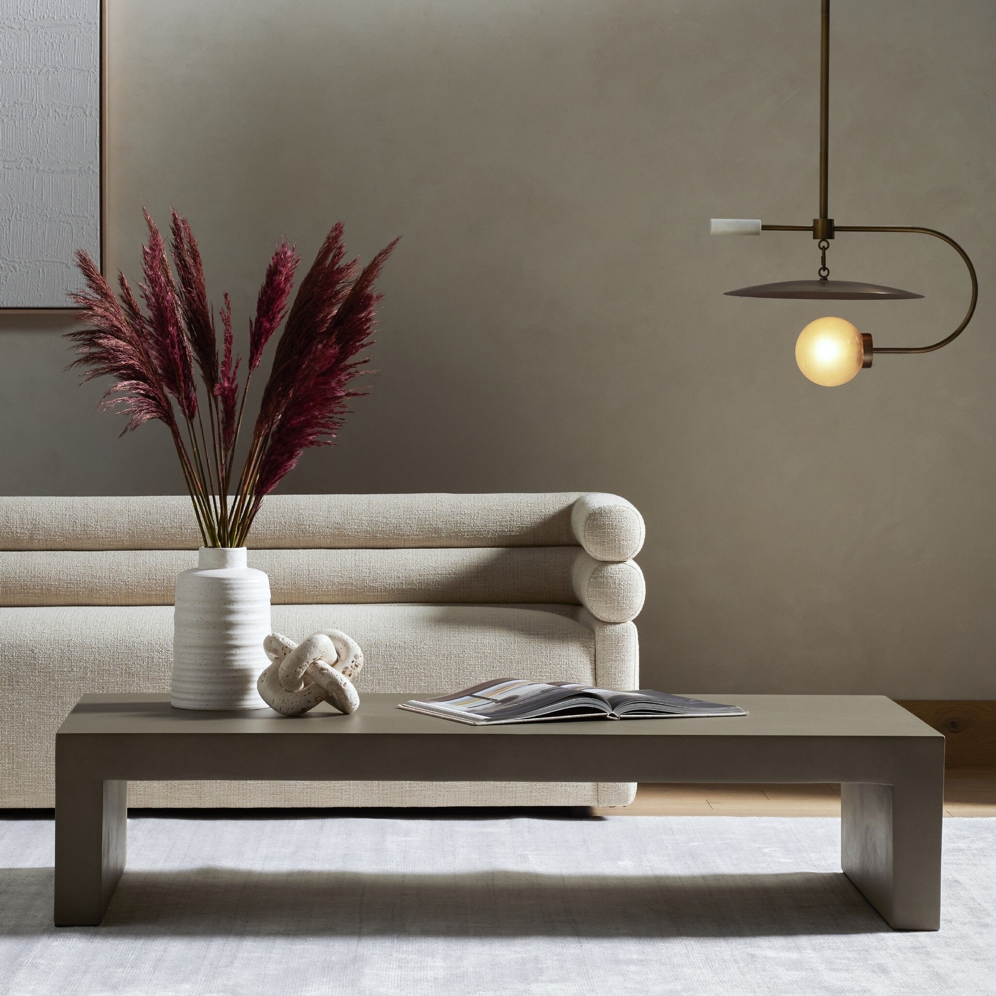 Modern living room with a beige sofa, coffee table, and decorative elements.