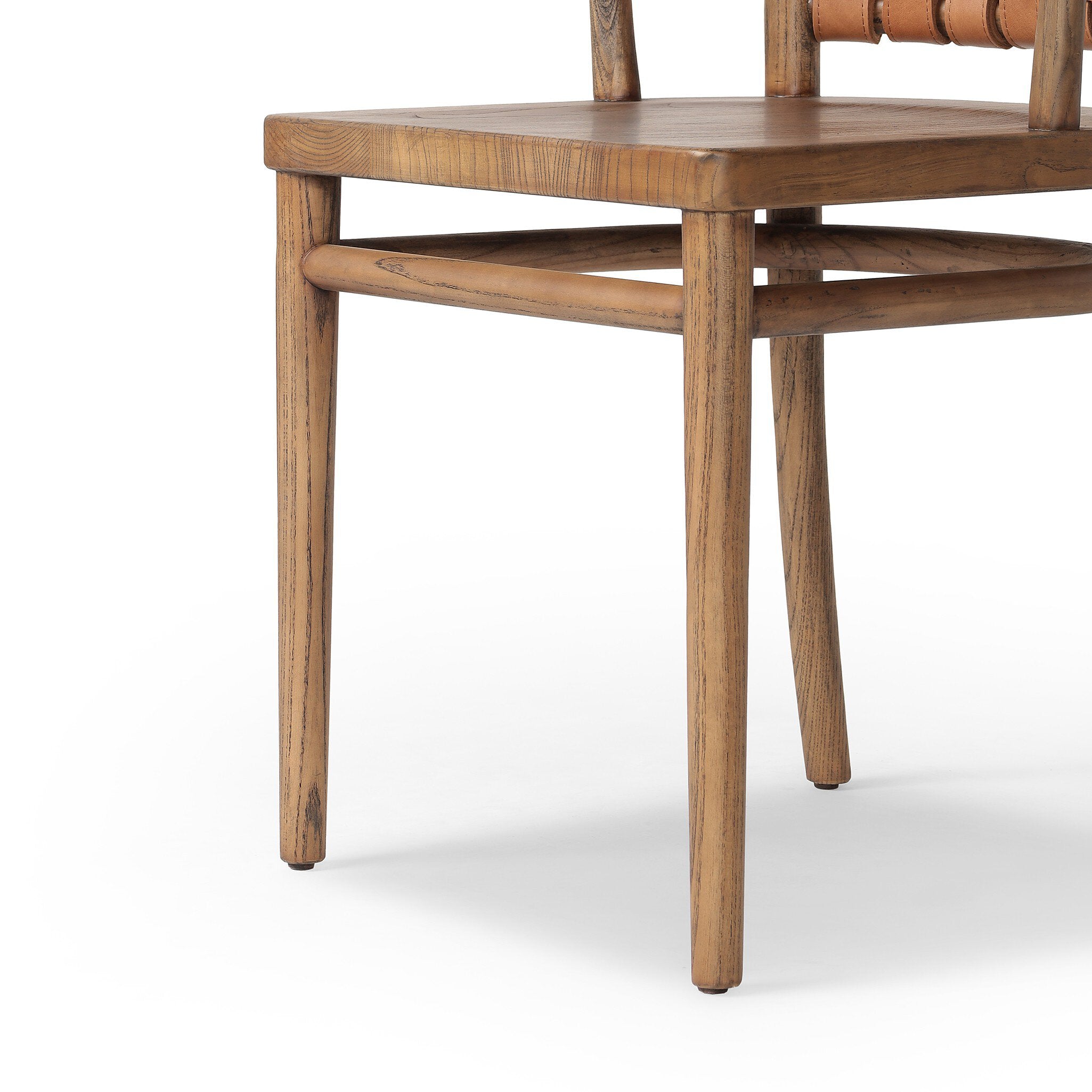 Close up of a wooden dining chair with barrel seatback of woven leather on a white background.