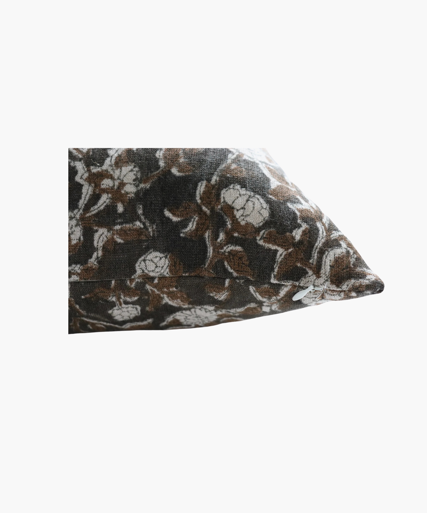 A detailed picture of a rectangular pillow  highlighting its  floral pattern of brown leaves and white flowers on a dark background. The design is intricate and evokes a cozy feel.