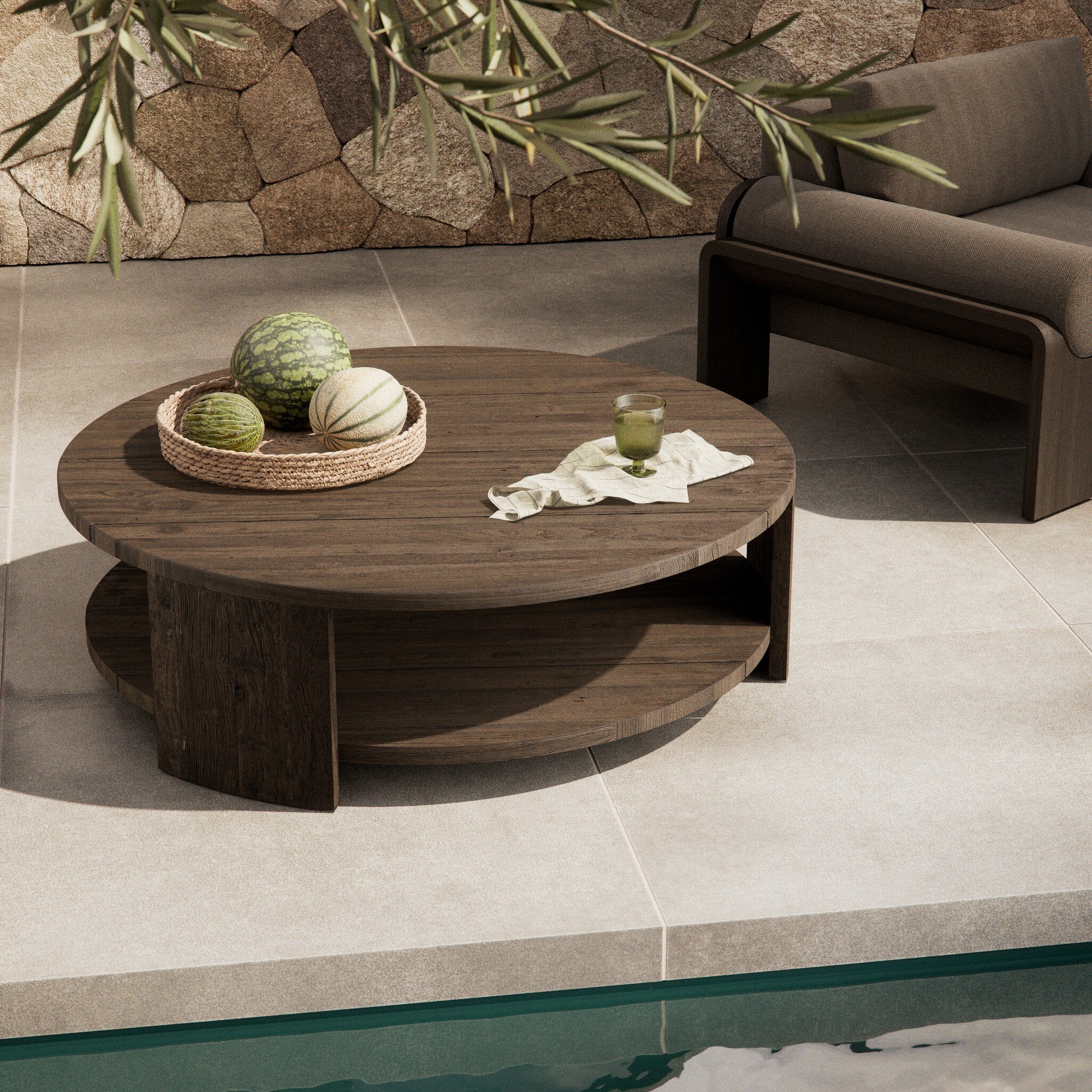 Round wooden coffee table with decorative items on a patio area.