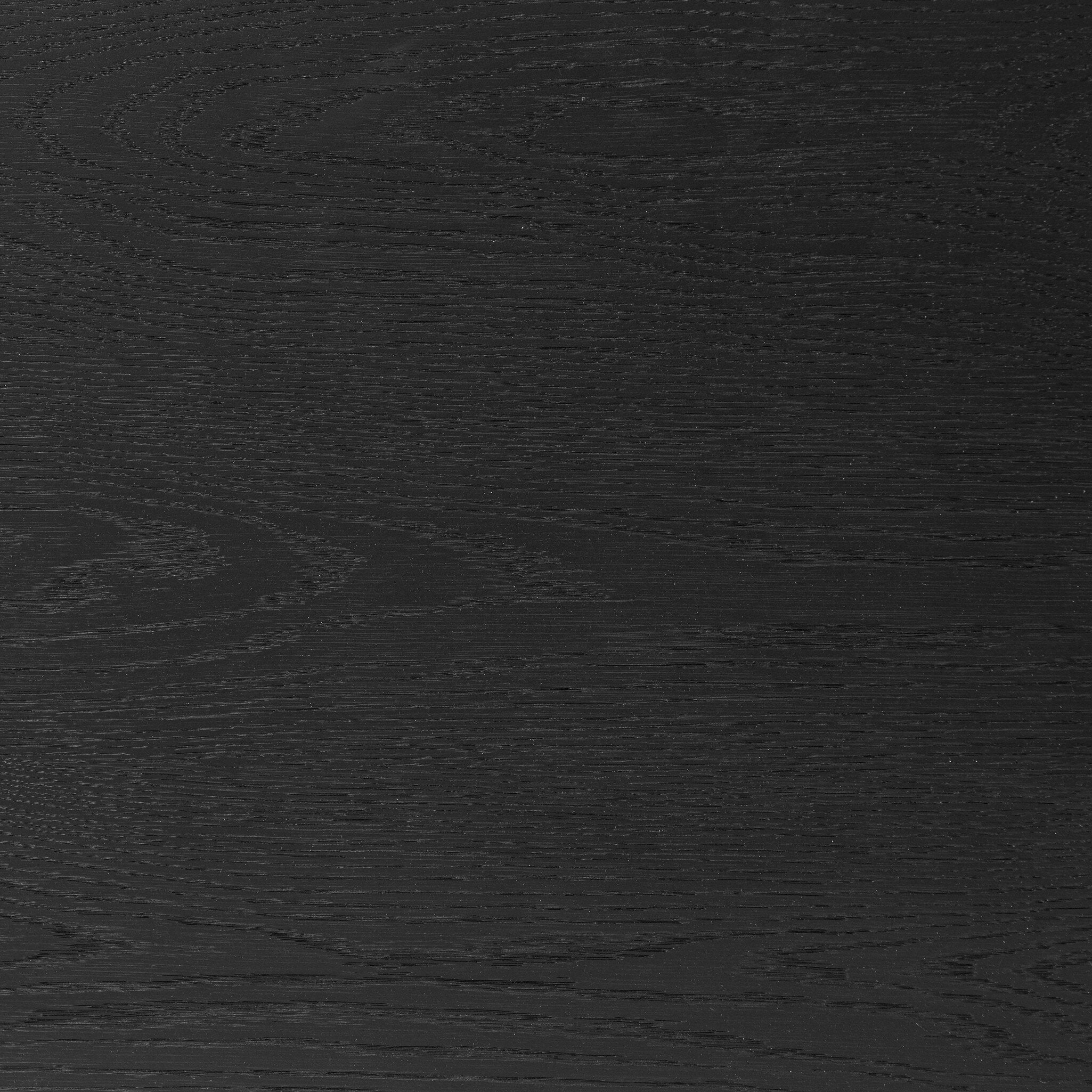 Close up of the top of the nightstand showing its black finish and oak wood grain. 