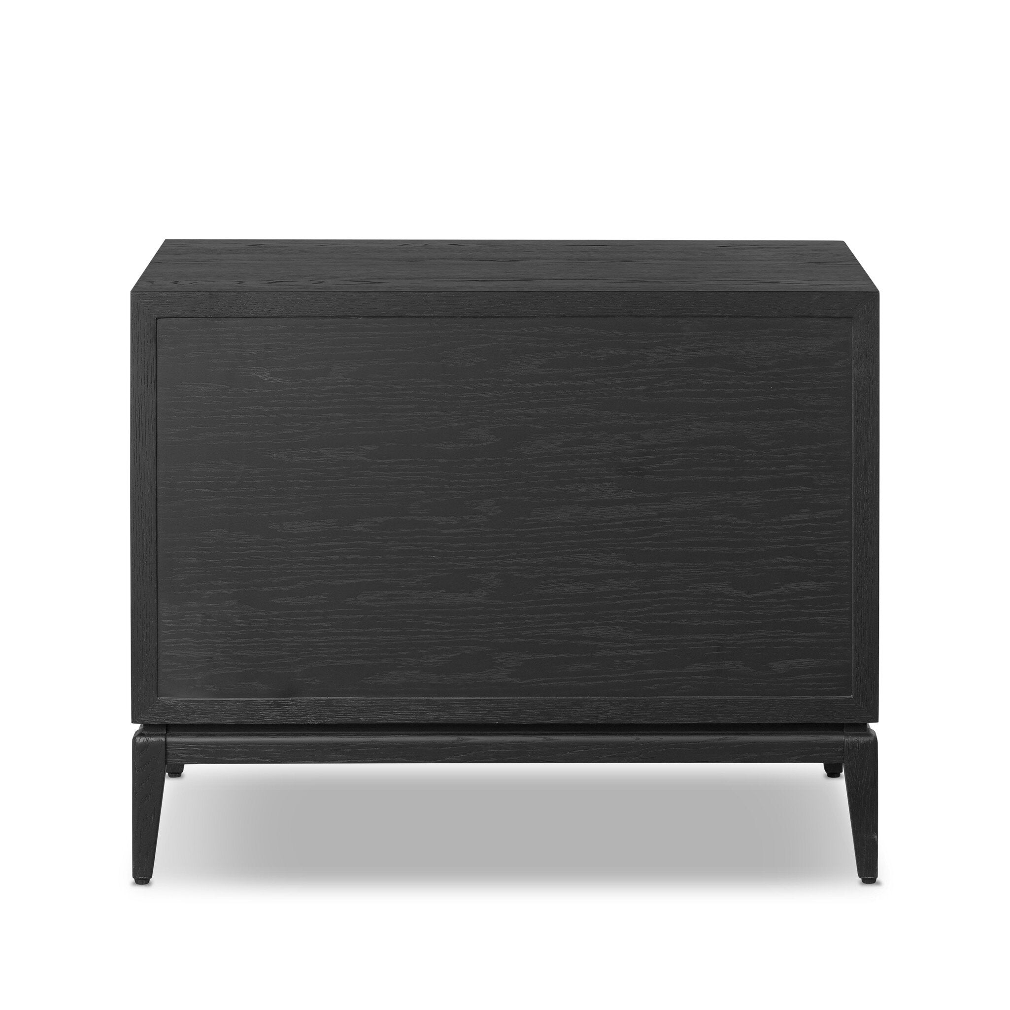 The back of a black-finished oak nightstand with a smooth top and single drawer front of woven paper on a white background. 