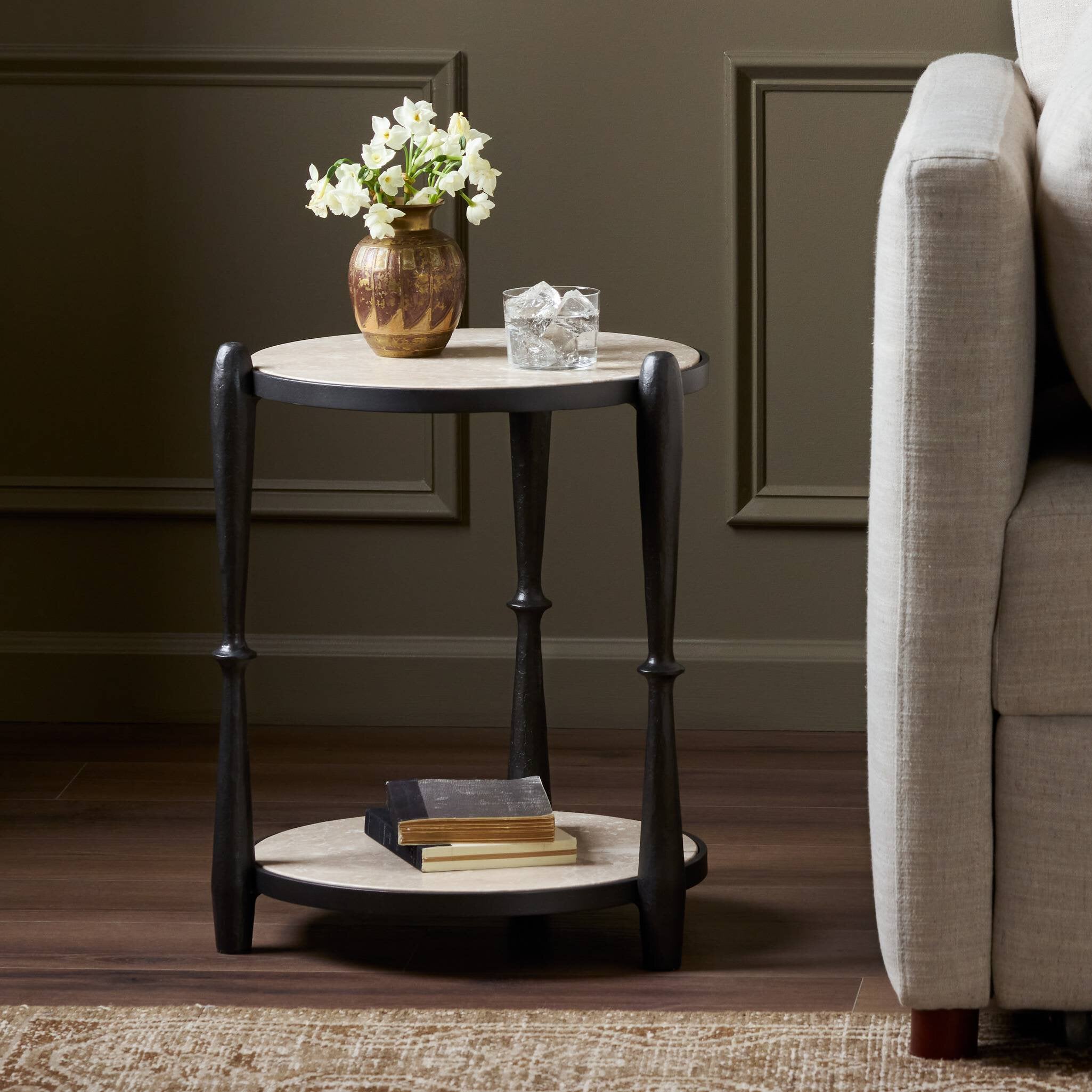 Small round side table with decorative items in a living room setting.