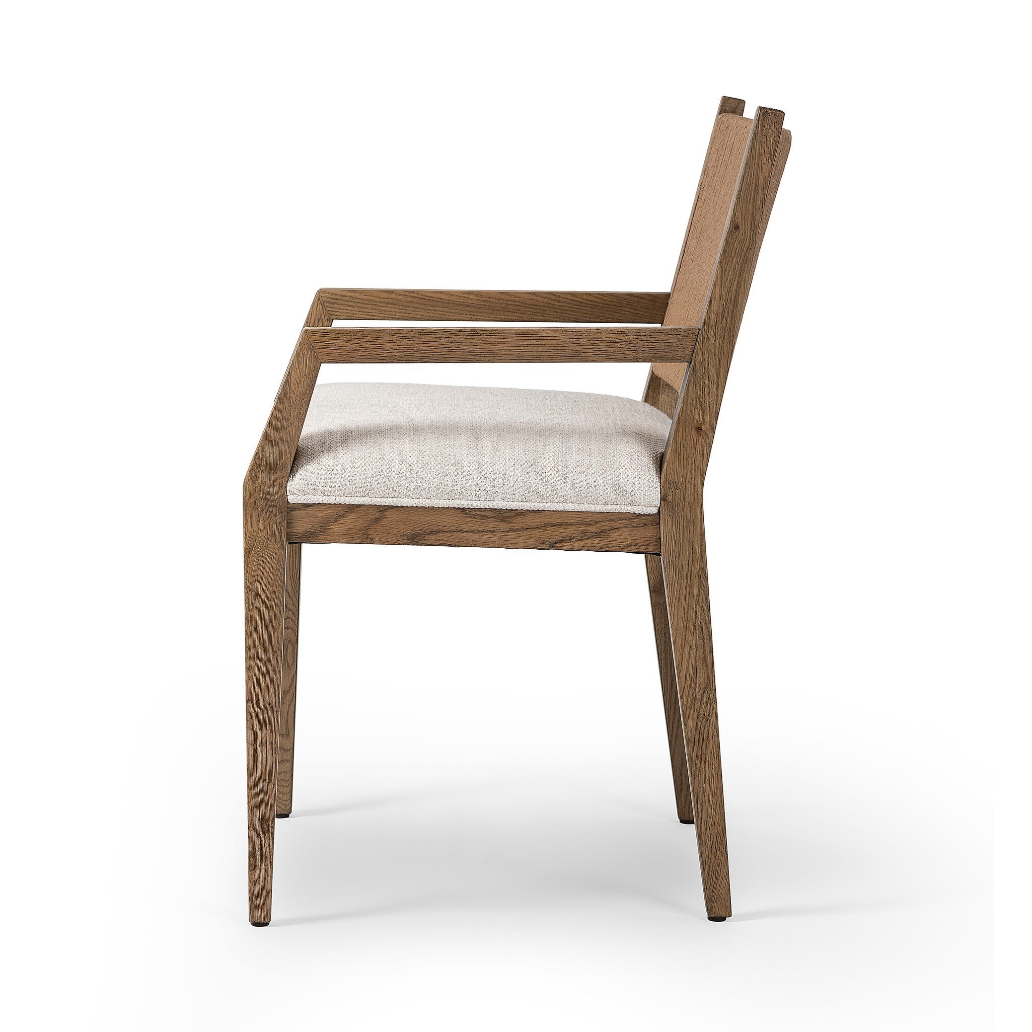 Side profile of a wooden dining arm chair with woven backrest and white cushion on a white background.