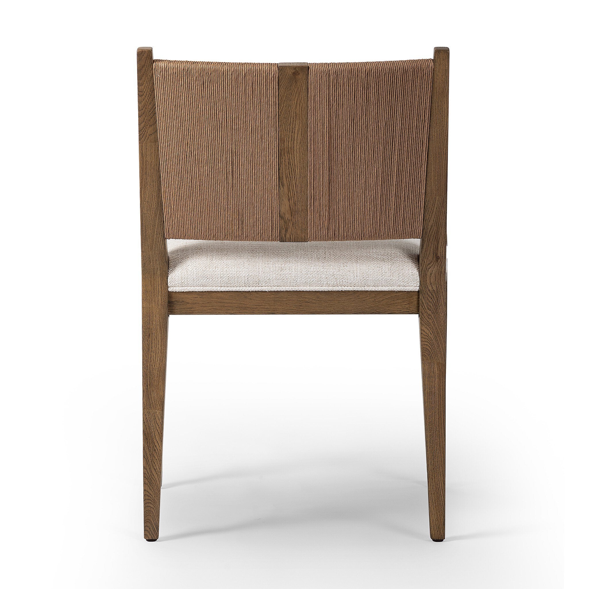 The back of a wooden dining arm chair with woven backrest and white cushion on a white background.