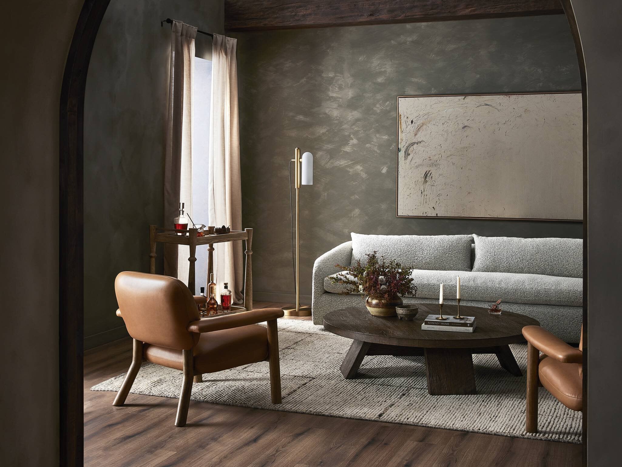 Modern living room with a gray sofa, wooden coffee table, and leather armchair.