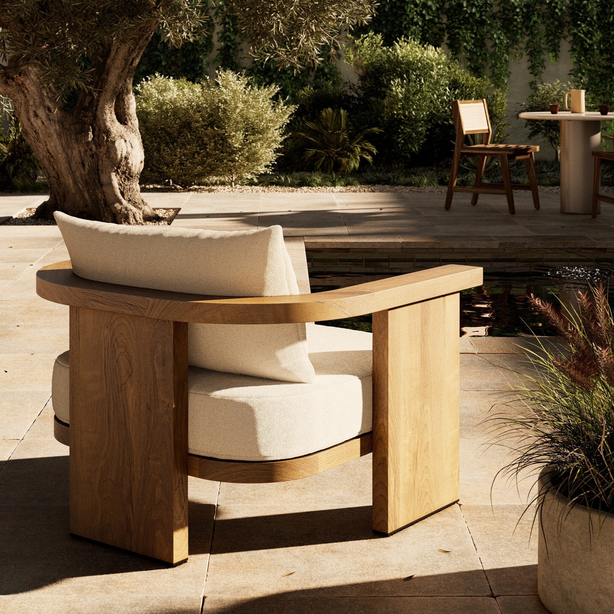 Wooden outdoor chair with white cushions on a patio by a pool. 
