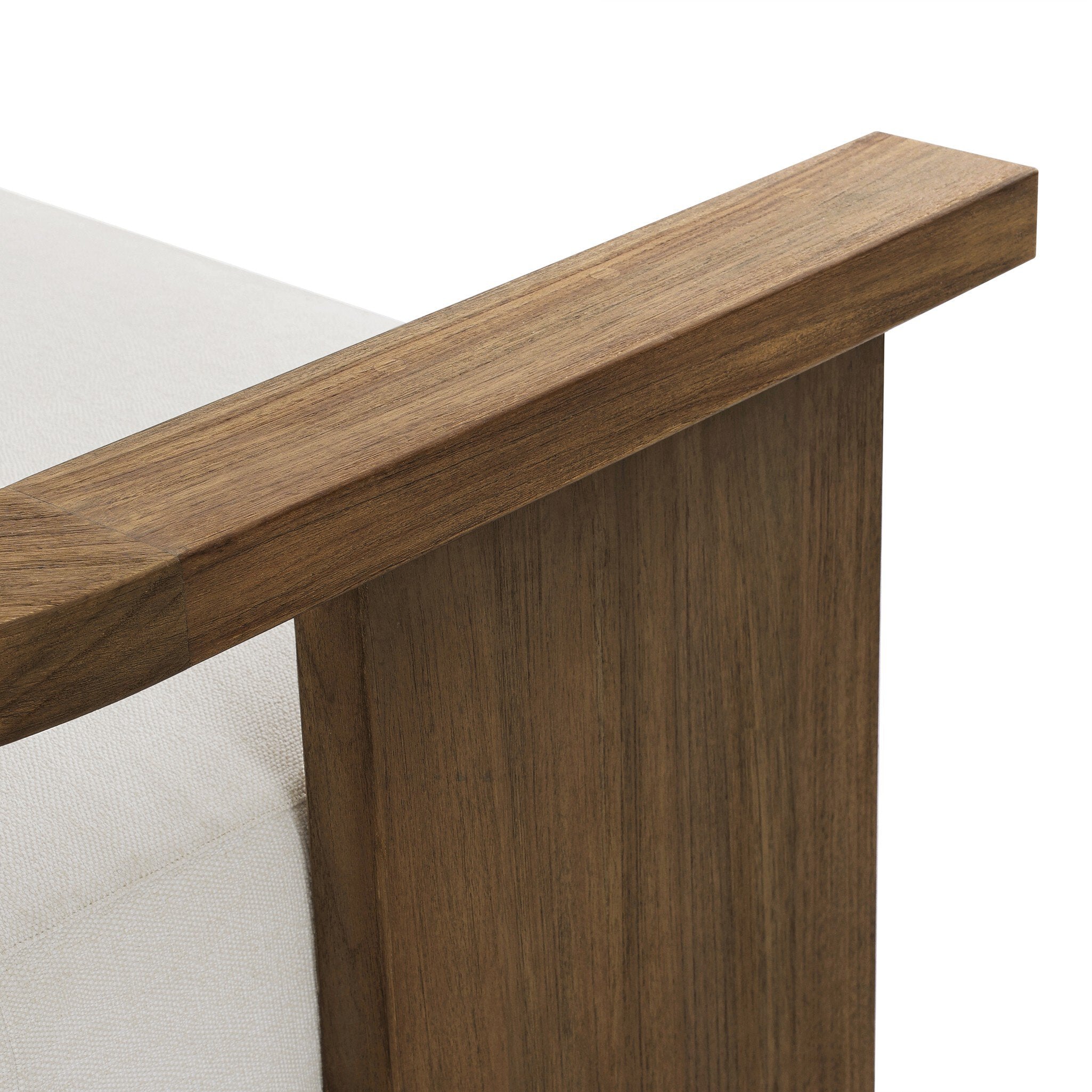 Close up of a outdoor sofa highlighting the white cushions and curved wooden frame. 