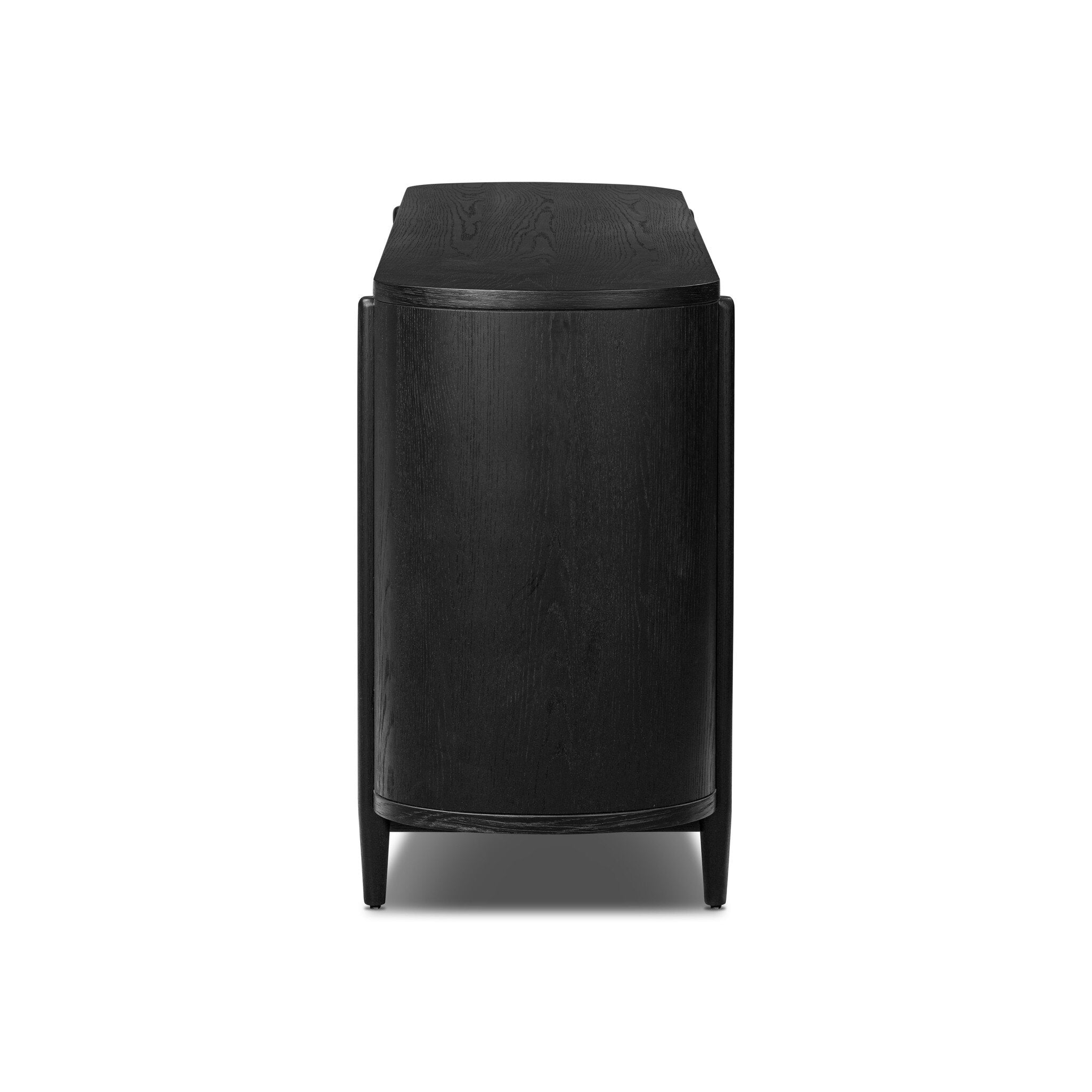 Side profile of a curved black dresser with brass handles on a white background.