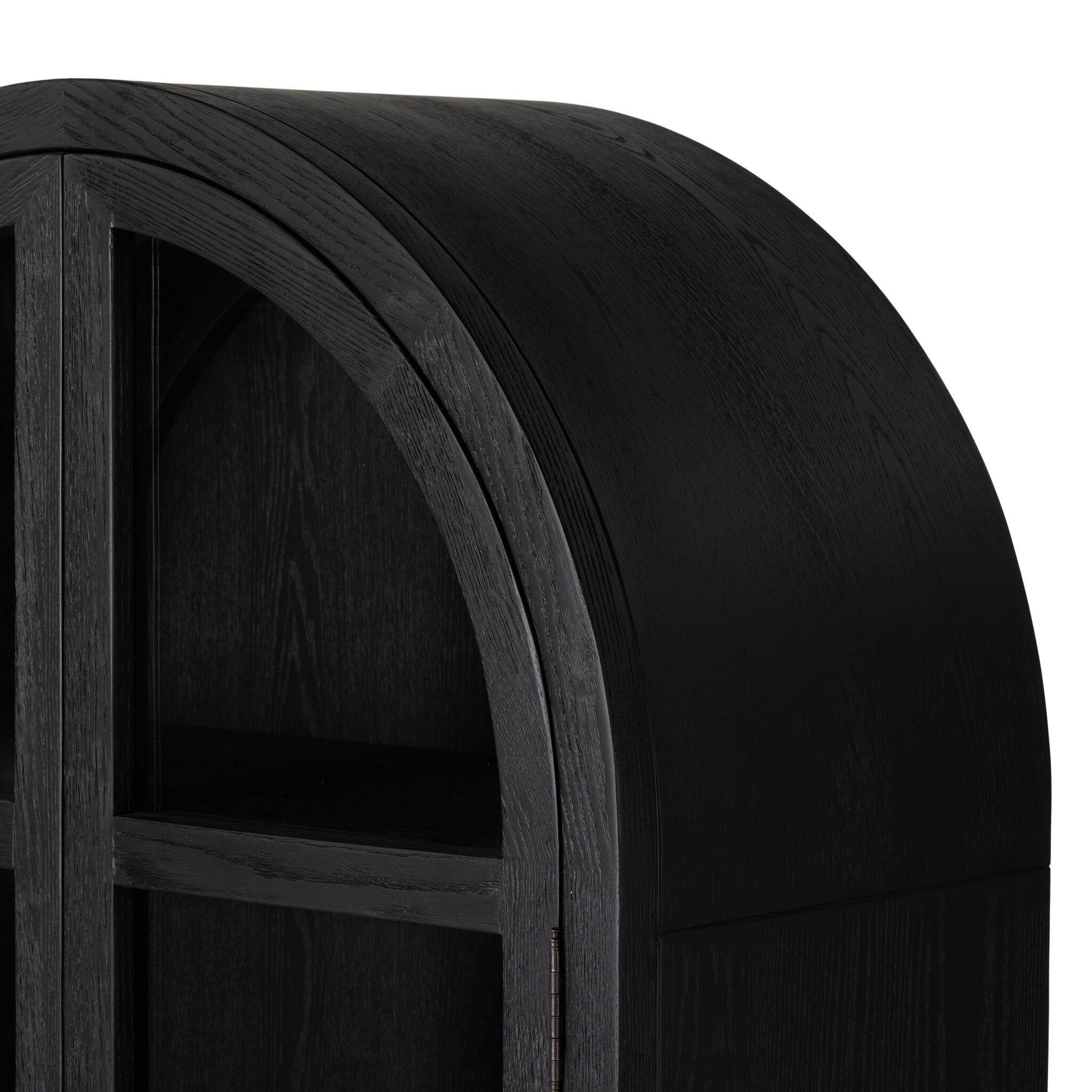 Close up of a black-finished solid oak cabinet with an arched top and glass doors.