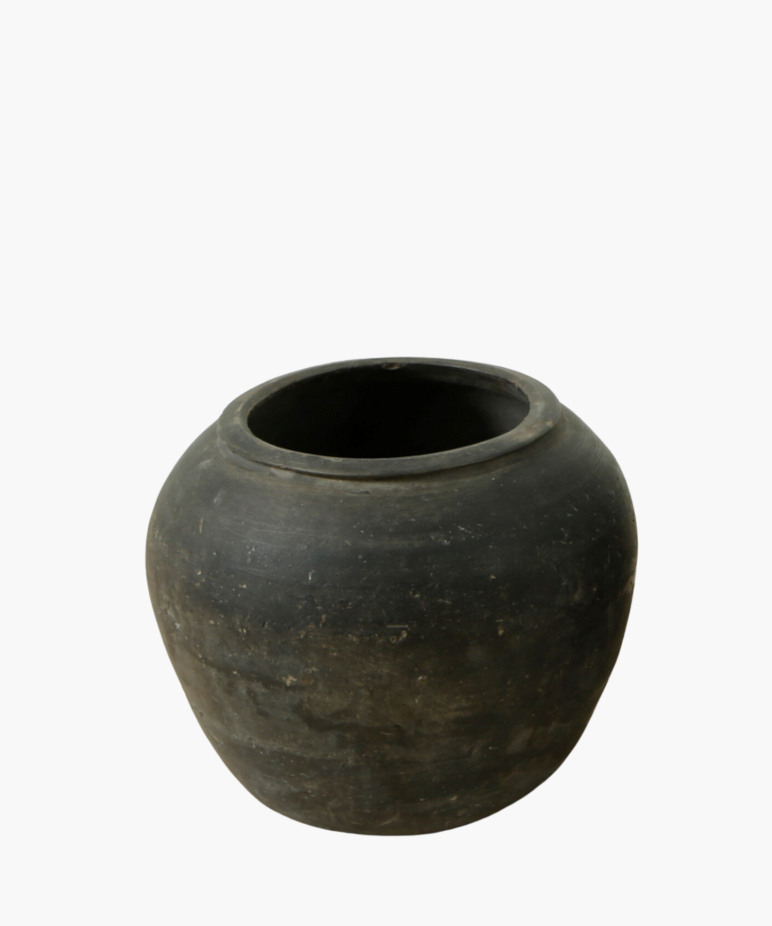 A round, rustic black clay pot with a smooth, matte finish. The pot has a wide opening and subtle texture, conveying a simple, earthy feel.