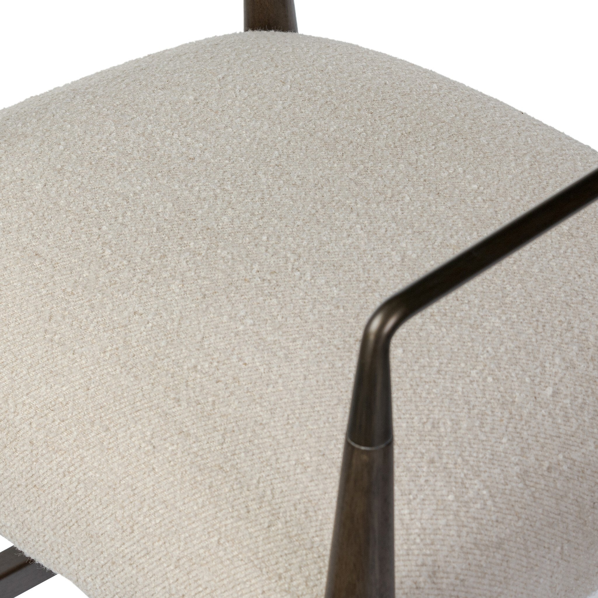 Close up of a bar stool with beige cushioned seat and backrest on a white background