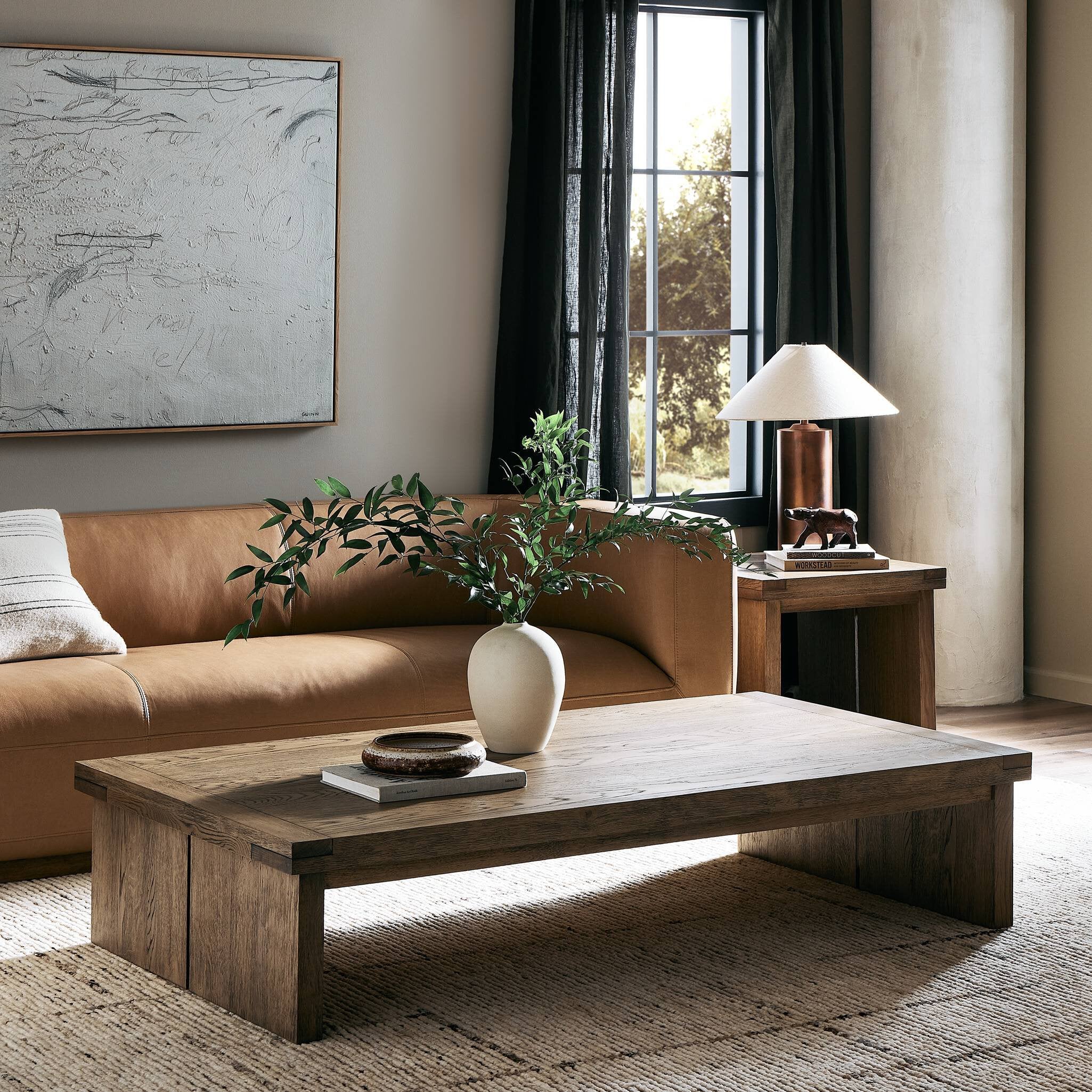 Living room with a brown sofa, wooden coffee table, and decorative items.