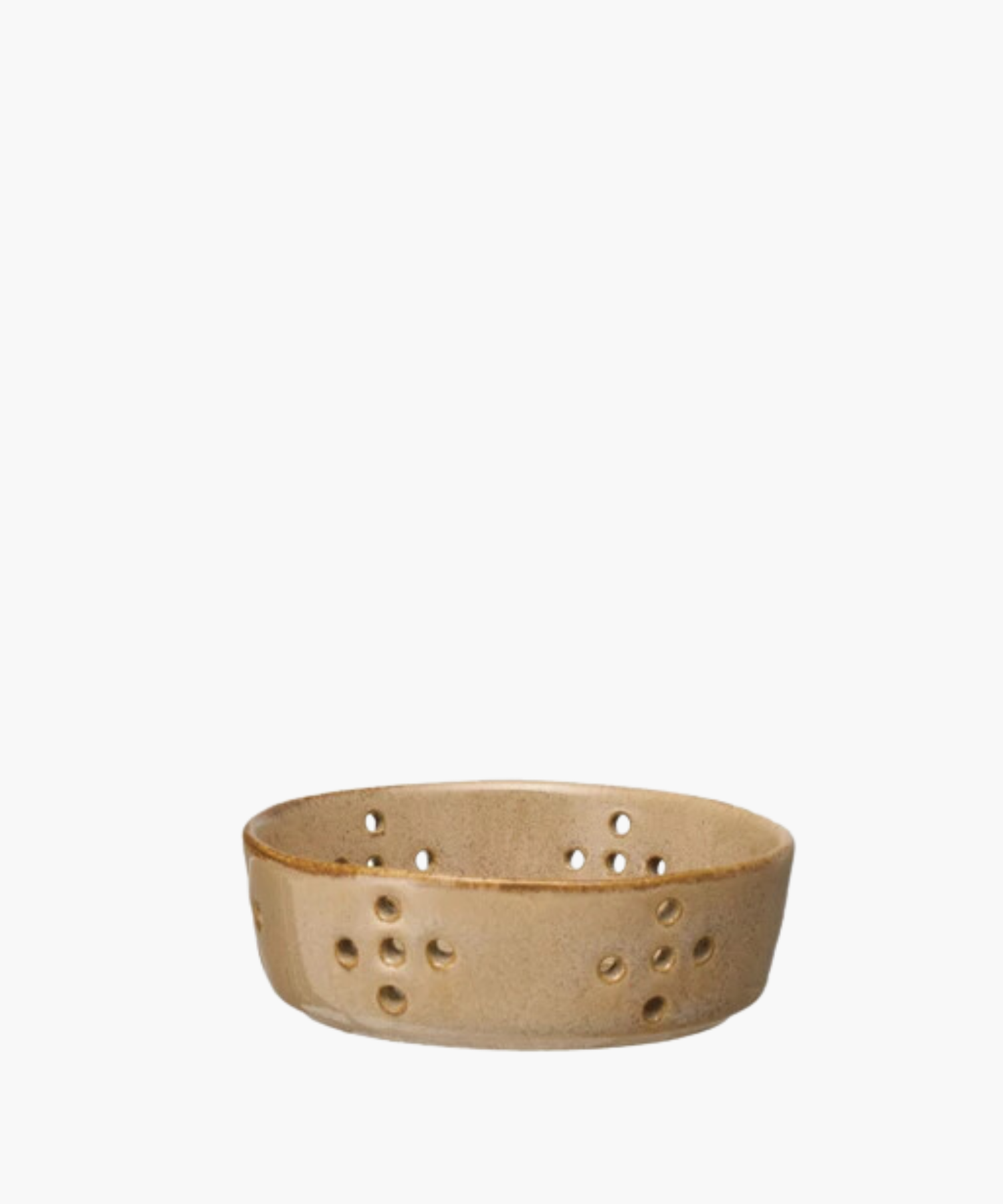 A beige ceramic colander features multiple circular drainage holes arranged in patterns. The bowl has a smooth, glazed finish, giving it a rustic appearance.