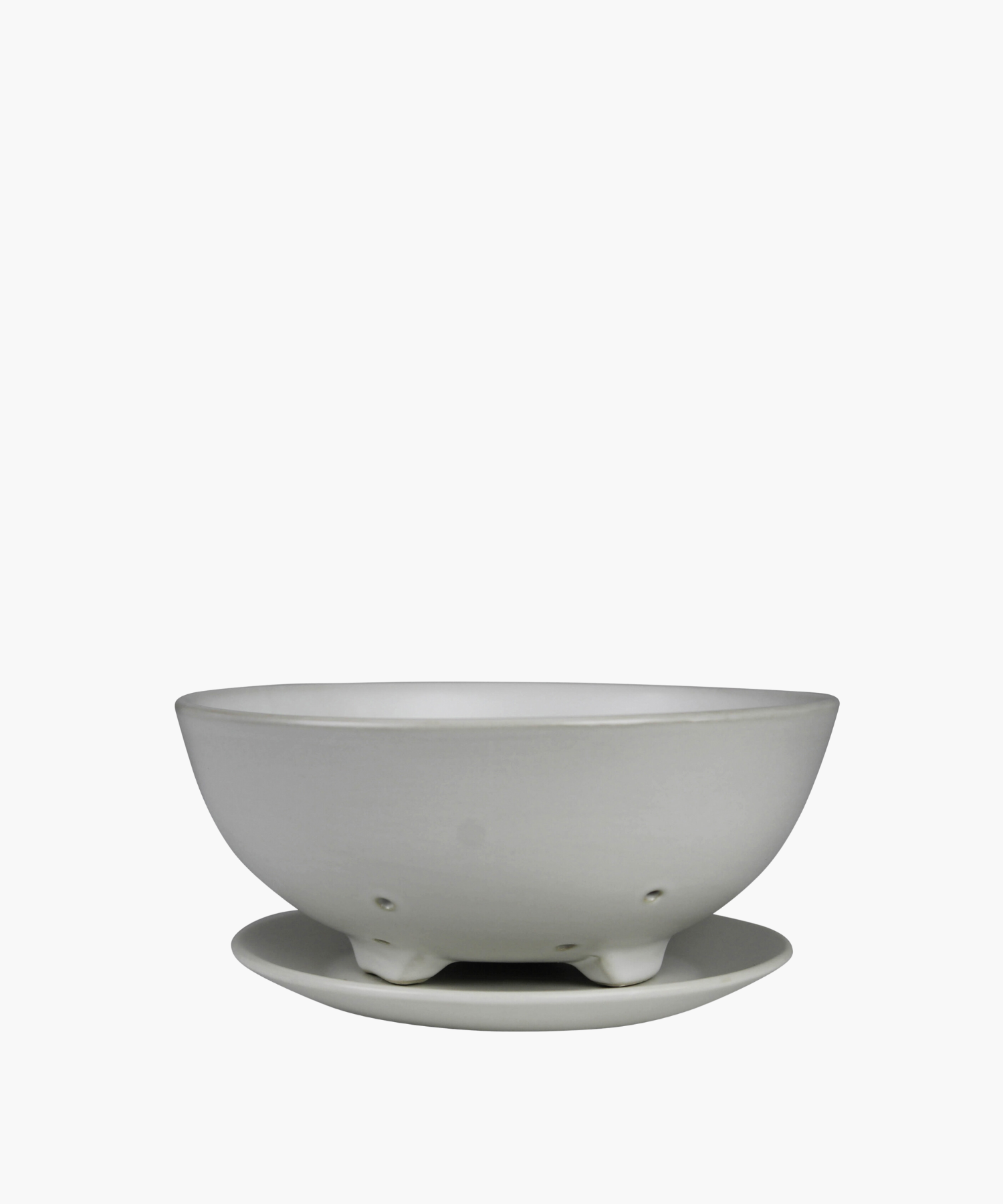 White ceramic colander with matching base plate. The minimalist design features a smooth matte finish, subtle curves, and small drainage holes.